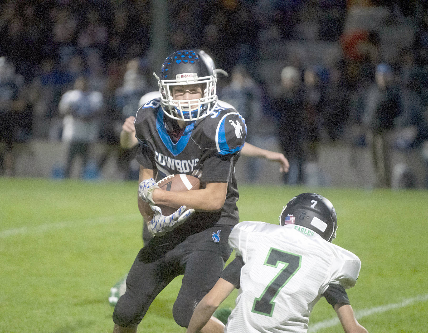<strong>Steve Mullensky</strong>/for Peninsula Daily News                                Chimacum’s Bjorn Danaan-Devas protects the ball after a 20-yard pass reception and avoids a tackle by Klahowya Eagle Michael Divano during a Friday night game at Memorial Field in Port Townsend.