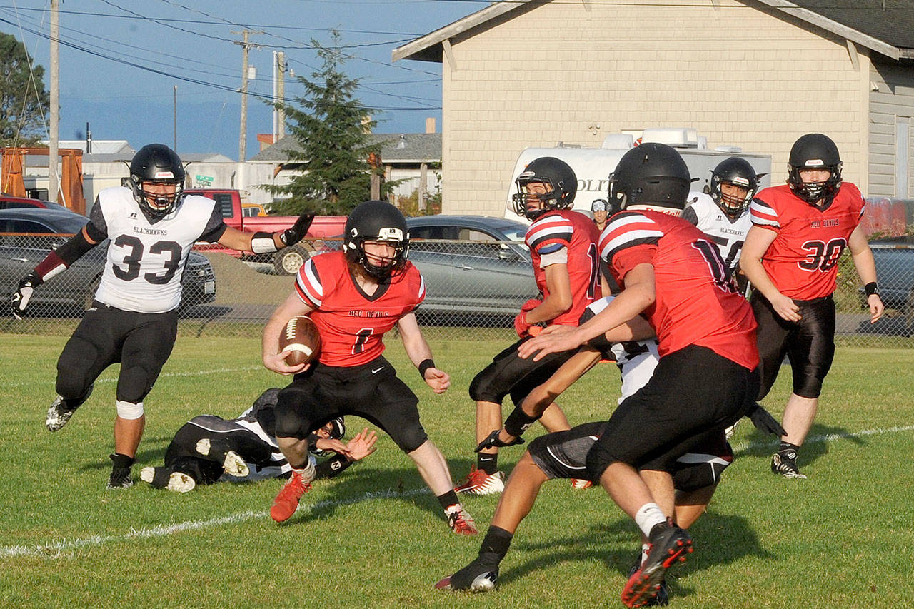 The Red Devils’ Meric Soeneke breaks free from Lummi defenders for another long gain Friday evening in Neah Bay. His teammate Toby Croy finished the game with 344 yards rushing. (Lonnie Archibald/for Peninsula Daily News)