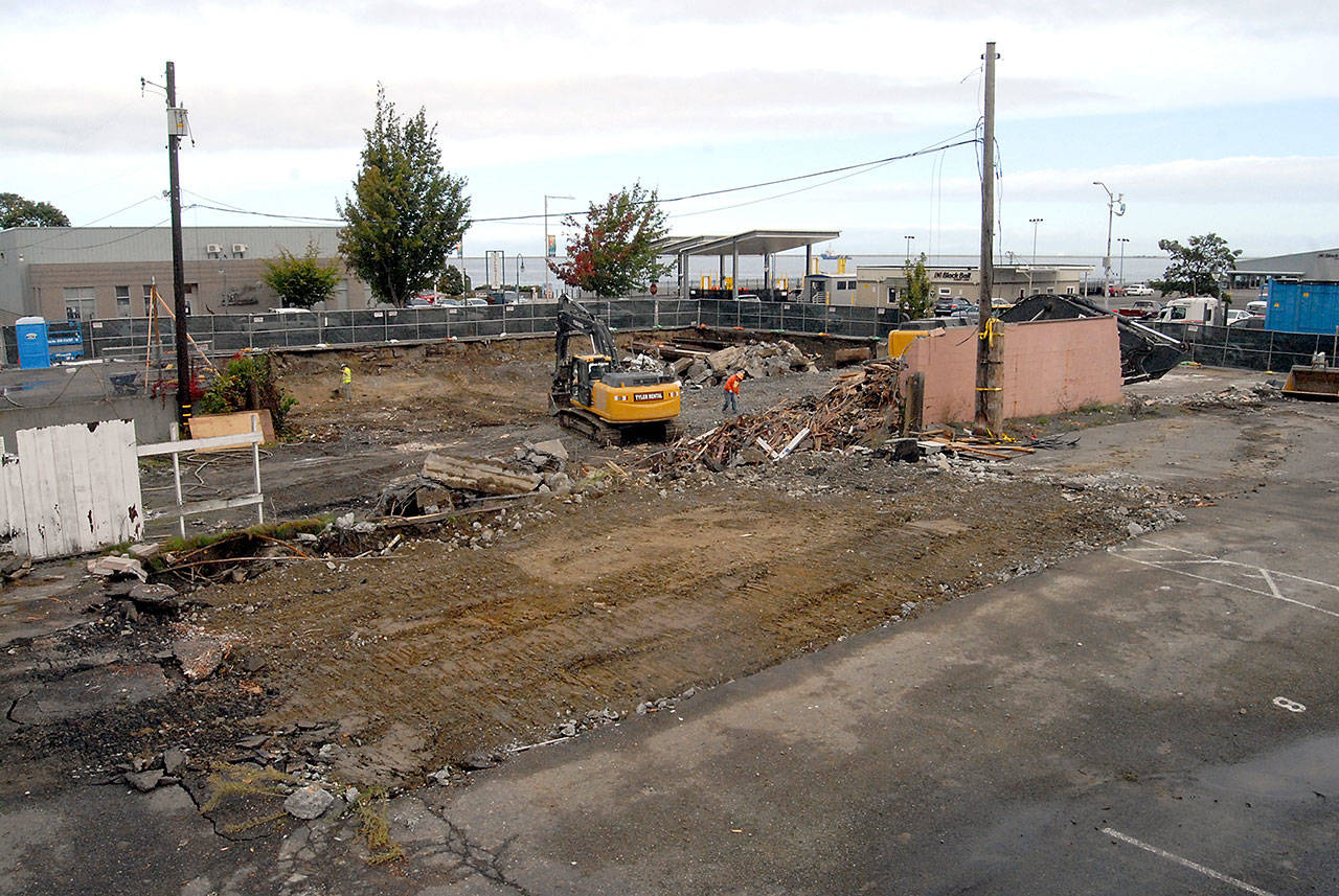 Crews work Thursday to remove the remains of demolished buildings at the site of a luxury hotel planned for downtown Port Angeles by the Lower Elwha Klallam Tribe. Buildings occupied by the Necessities & Temptations gift shop, Harbor Arts gallery and Budget/Avis car rental have been razed so far. (Keith Thorpe/Peninsula Daily News)