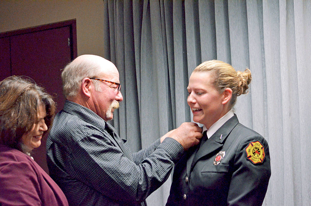 Newly promoted Lieutenant Stephanie Anderson, right, is pinned by her parents, Penny and Curt Gates.