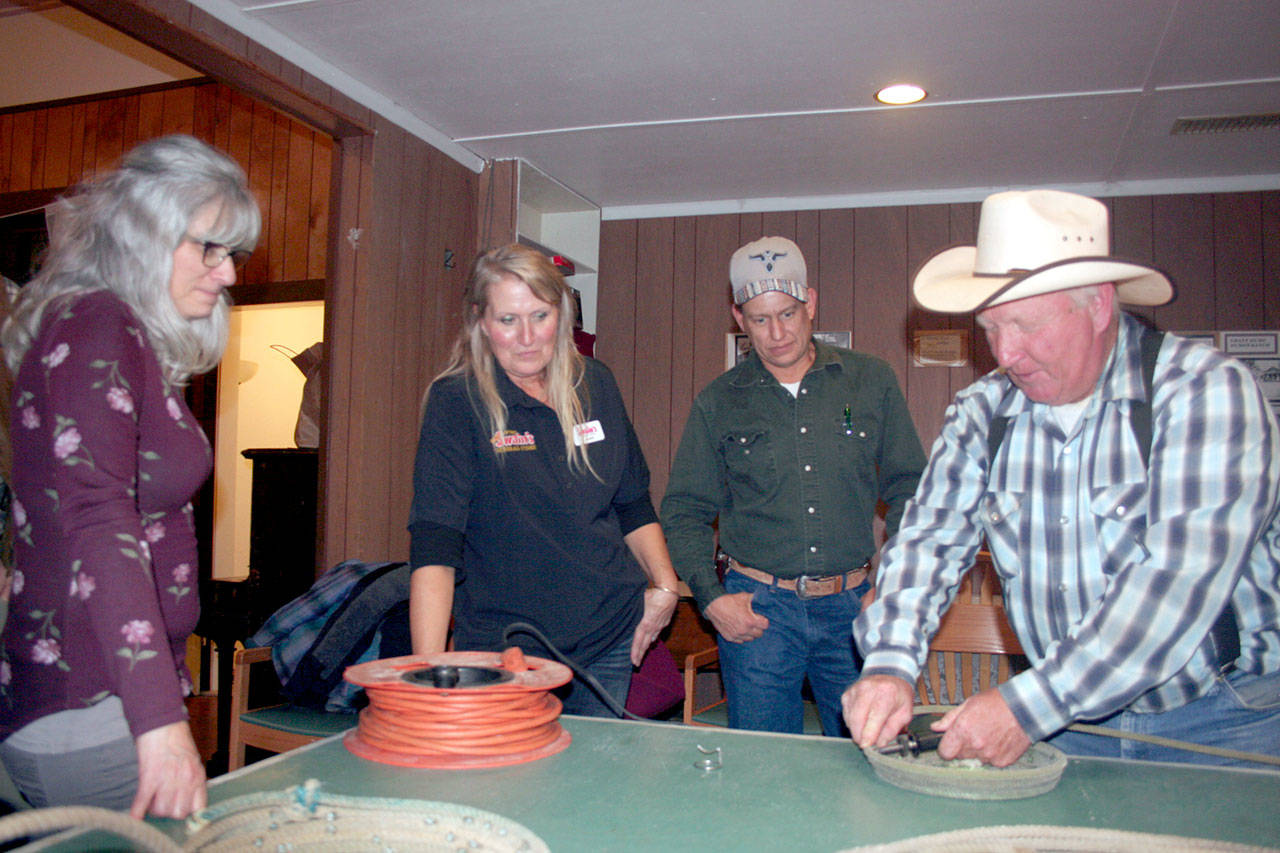 Olympic National Park’s mule packer Boone Jones, right, shows Back Country Horsemen’s Mount Olympus Chapter members Rochelle Sutherland, Penny Doan and Curtis Wright how to make rope baskets out of old lariats during the group’s monthly meeting and potluck dinner. (Karen Griffiths/for Peninsula Daily News)