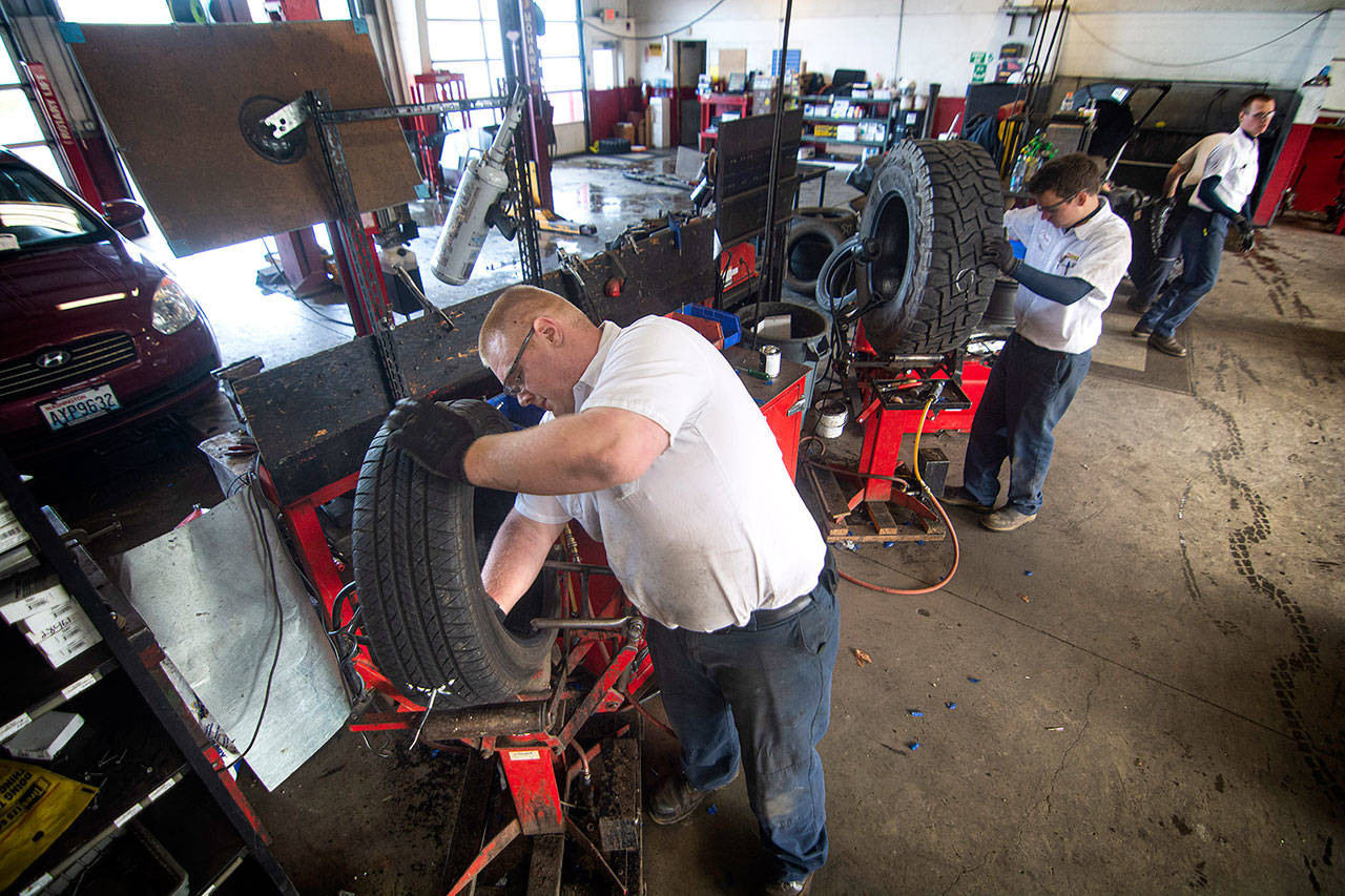Zach Bucklin repairs a tire at Les Schwab in Port Angeles on Tuesday after about customers reported picking up screws in their tires on U.S. Highway 101 at Morse Creek. (Jesse Major/Peninsula Daily News)