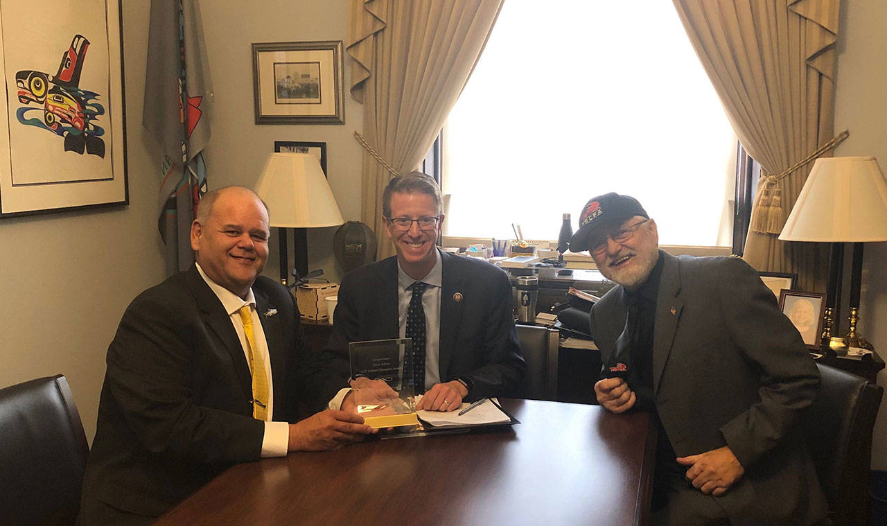U.S. Rep. Derek Kilmer, center, receives the Coalition of Coastal Fisheries’ 2019 Salmon Champion Award from Butch Smith, left, a third-generation salmon and sturgeon fishing charter captain who serves as the Ilwaco Port Commissioner, and Dale Beasley, president of the Coalition of Coastal Fisheries and of the Columbia River Crab Fishermen’s Association.