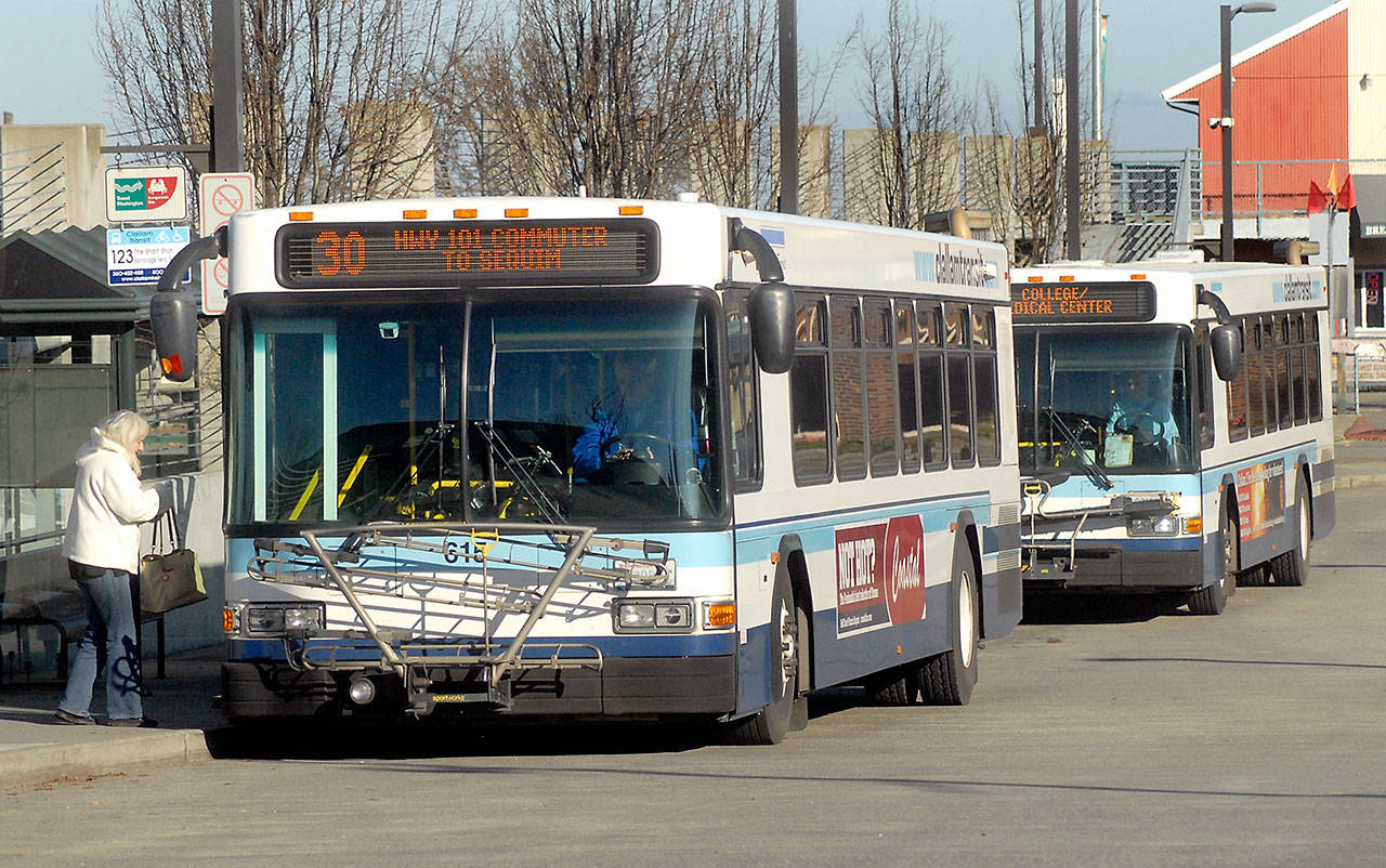 A pair of Clallam Transit buses board passengers at The Gateway transit center in downtown Port Angeles on Thursday. (Keith Thorpe/Peninsula Daily News)
