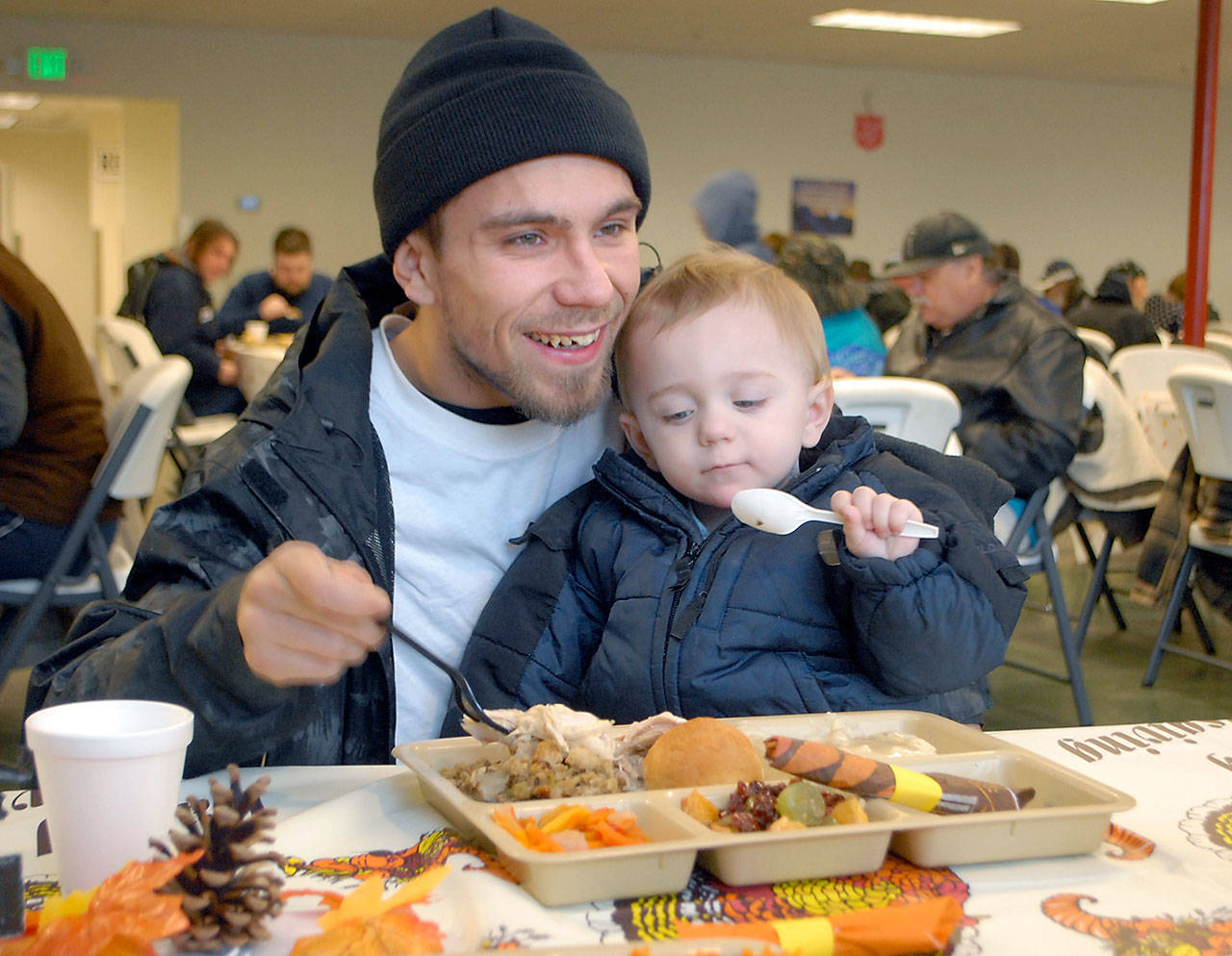 Michael Reyes of Port Angeles and his son, Maison Reyes, 15 months, share a meal at the Port Angeles Salvation Army kitchen Wednesday. (Keith Thorpe/Peninsula Daily News)