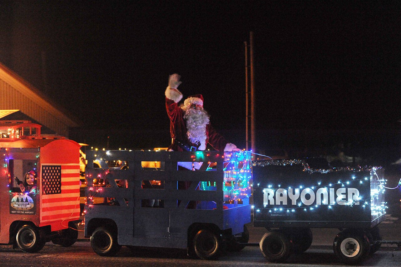 Santa rides on the West End Business & Professional Association’s train during last year’s Twinkle Light Parade down Forks Avenue, en route to the Christmas tree lighting. (Lonnie Archibald/Peninsula Daily News file)