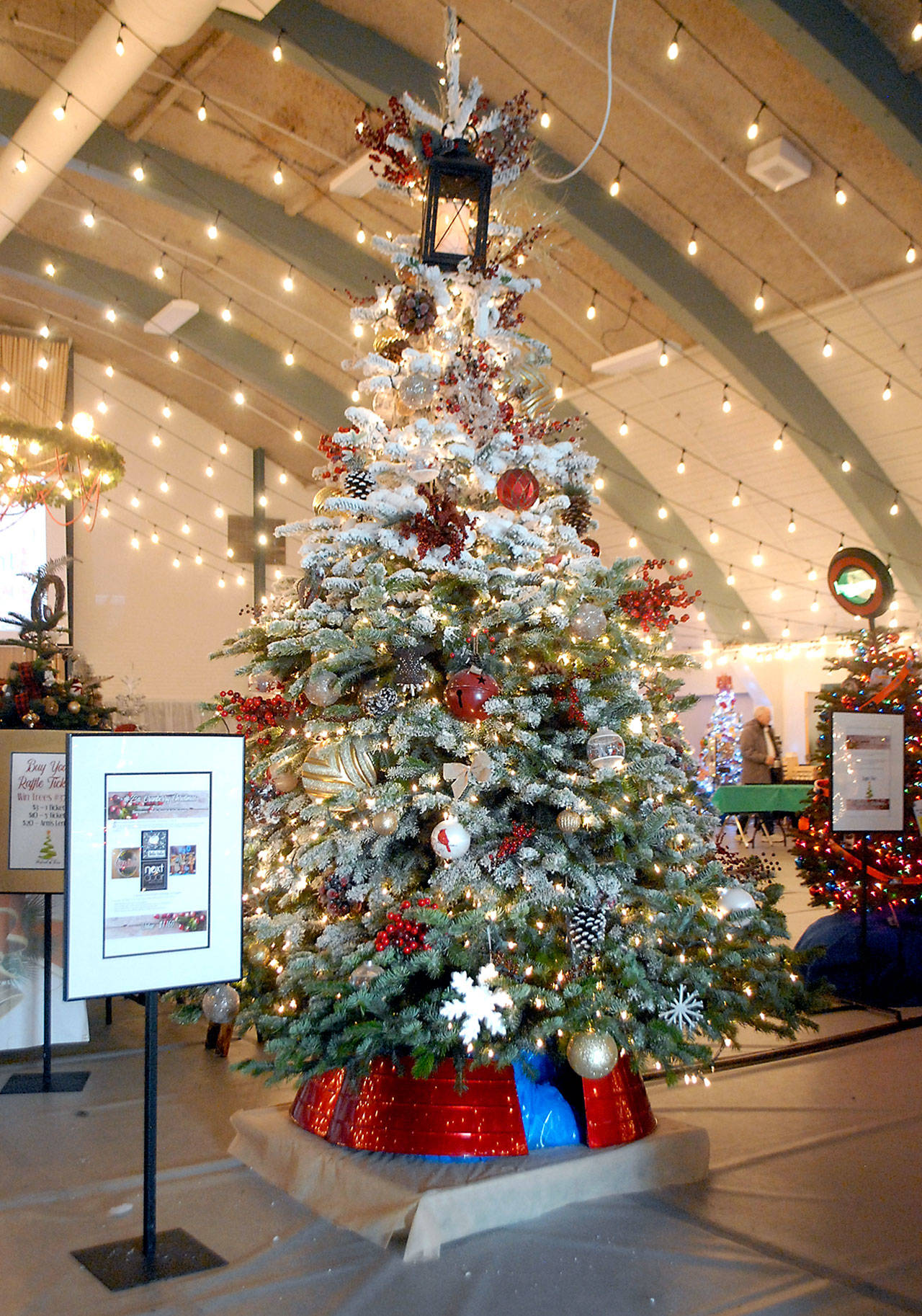 A Christmas tree titled “Cranberry Christmas” stands tall in Vern Burton Community Center in Port Angeles on Saturday after fetching a top bid of $5,500 at Friday’s Festival of Trees gala auction. The tree included the premium of a moving feast of dinner four eight at four downtown Port Angeles eateries, as well as a porch bench. “Cranberry Christmas” was sponsored by Rinehart Consulting and designed by Molly Smith. (Keith Thorpe/Peninsula Daily News)