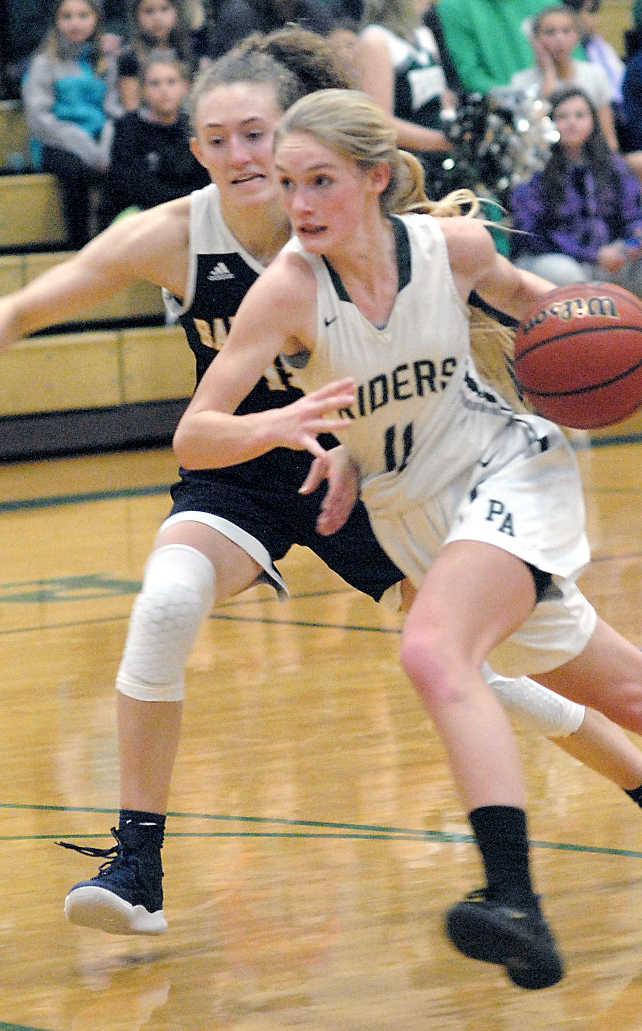 Port Angeles’ Millie Long, front, drives past Bainbridge’s Olivia Wikstrom on Tuesday in Port Angeles. (Keith Thorpe/Peninsula Daily News)