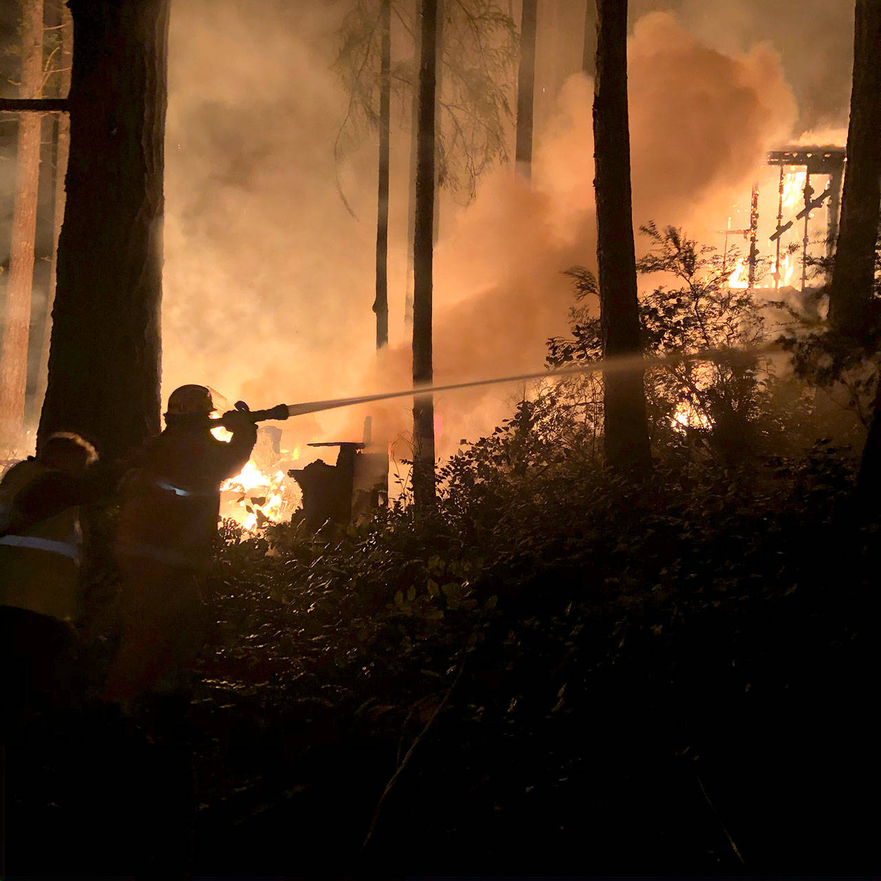 Firefighters work to put out a fire on Alder Street in Coyle on Monday night. No one was injured but the fire consumed a trailer, damaged a guest house and threatened a residential home. (Jefferson County Sheriff’s Office)