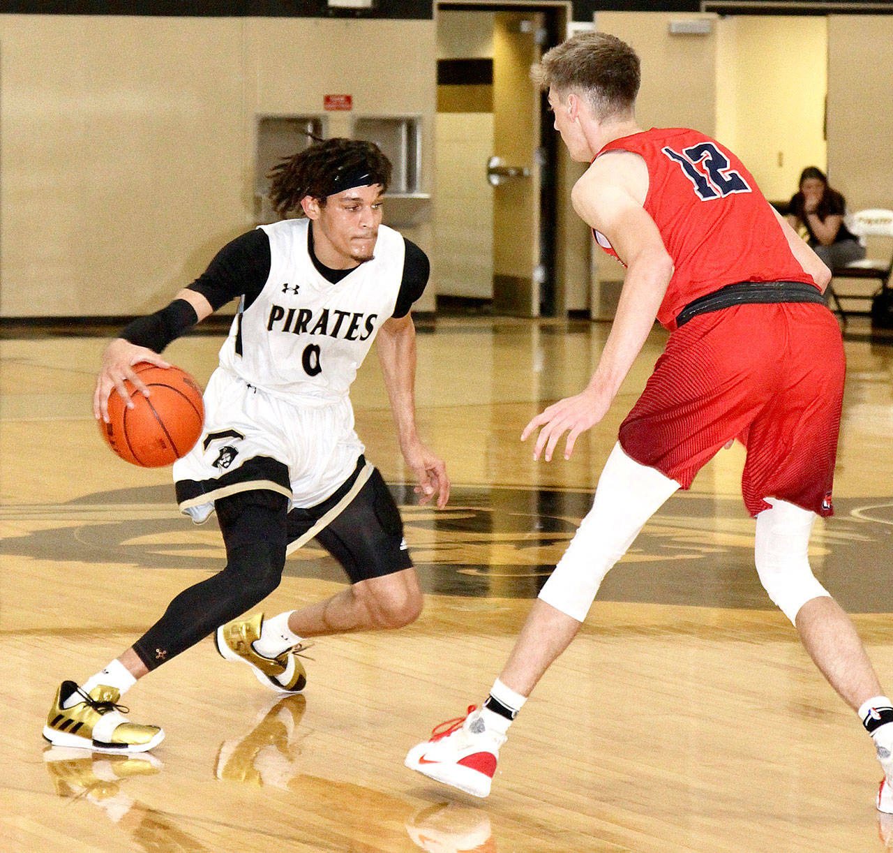 Peninsula College’s Jaylin Reed (0) dribbles against Clackamas’ Michael Bashaw in Sunday’s Wilder Pirate Classic game in Port Angeles. Clackamas won 89-82. (Dave Logan/for Peninsula Daily News)