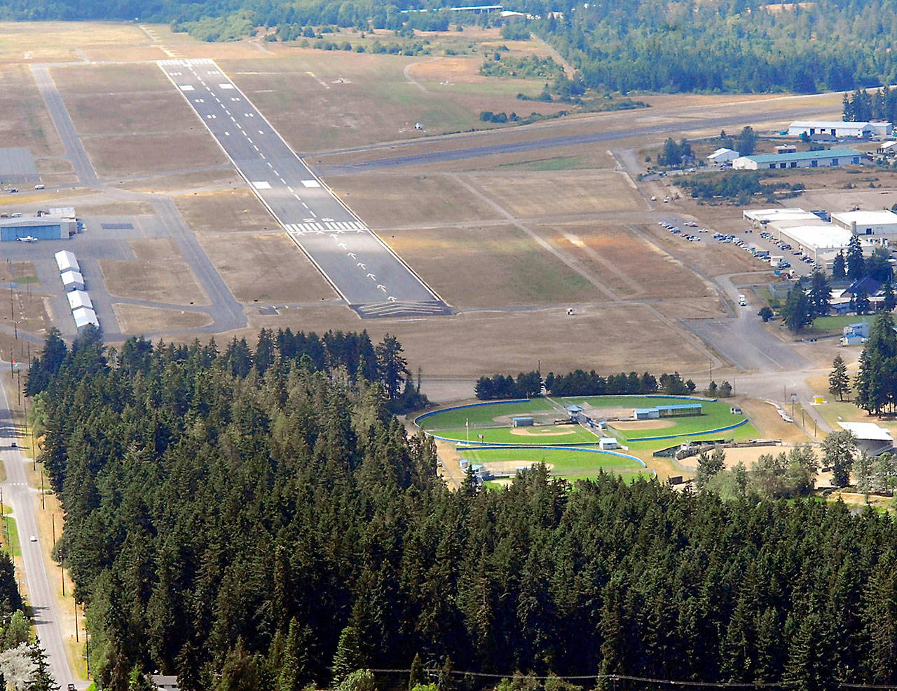 The 6,347-foot long main runway at William R. Fairchild International Airport in Port Angeles, known officially as 08/26, is shown in this July 2011 file photo. The heavily forested Lincoln Park with its athletic fields is shown at bottom. (Keith Thorpe/Peninsula Daily News)