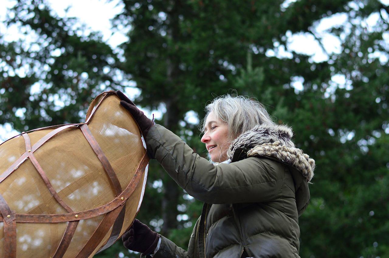 Boise artist Katherine Shaughnessy adjusts “Tempest-tost,” her sculpture atop the Port Angeles Fine Arts Center roof. (Sarah Jane/Port Angeles Fine Arts Center)