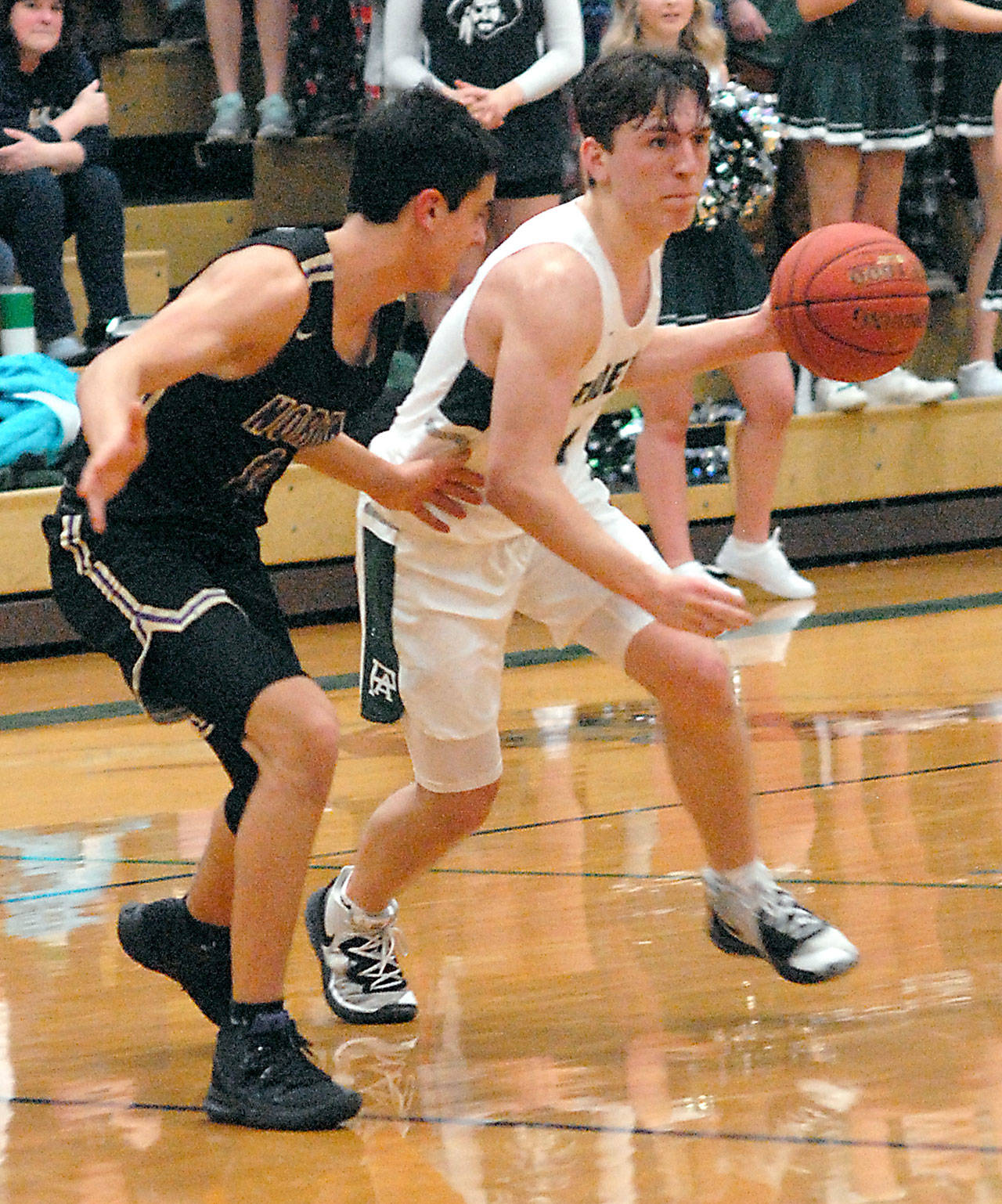 Port Angeles’ Gary Johnson, right, heads for the lane as North Kitsap’s Johny Olmsted defends on Wednesday at Port Angeles High School.                                Keith Thorpe/Peninsula Daily News