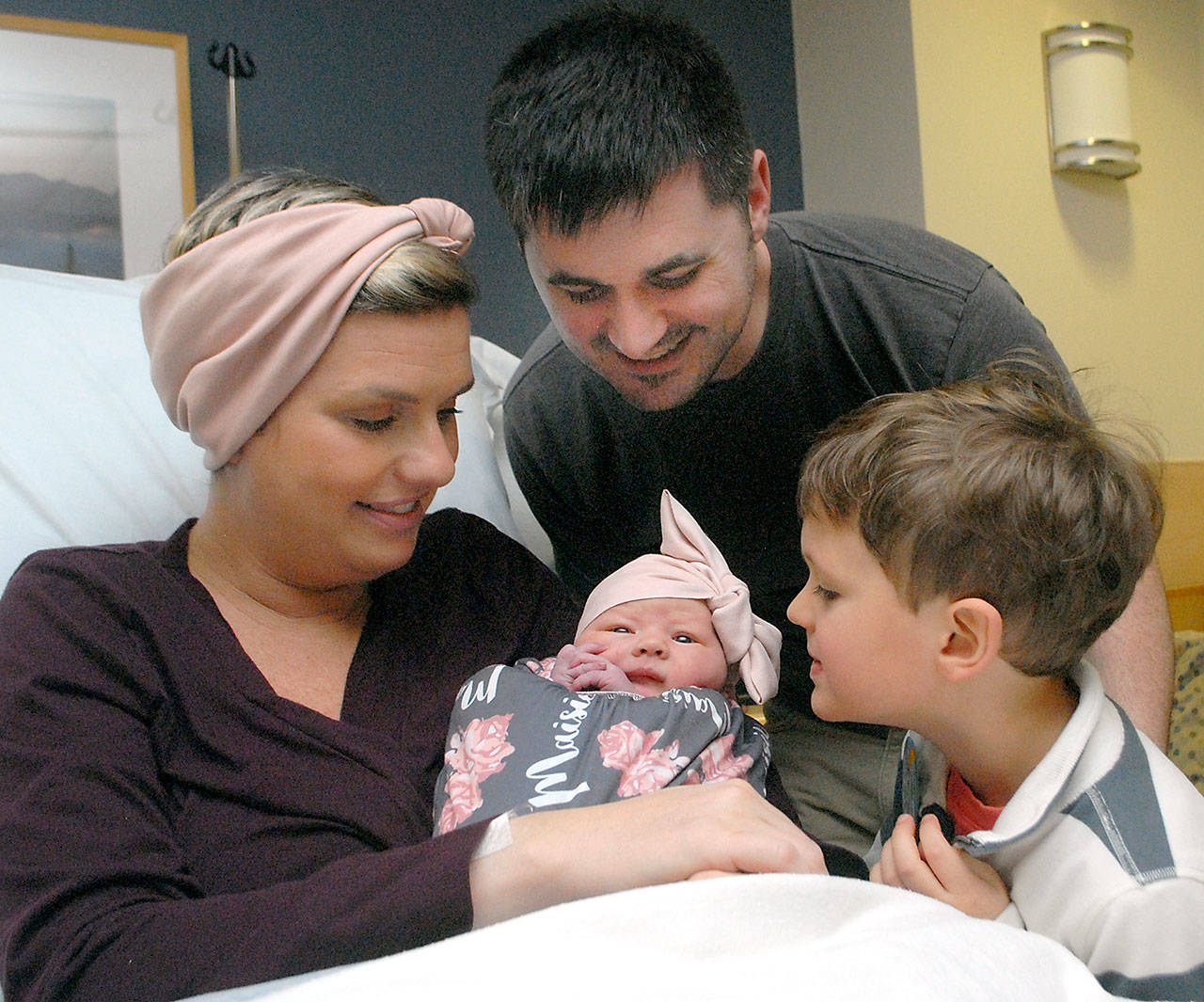 Parents Megan and Jon Lee of Port Angeles look at their newborn daughter, Maisie Miller Lee, the first baby in Clallam County for 2020, as Jack Lee, 5, admires his new sister at Olympic Medical Center on Wednesday. (Keith Thorpe/Peninsula Daily News)