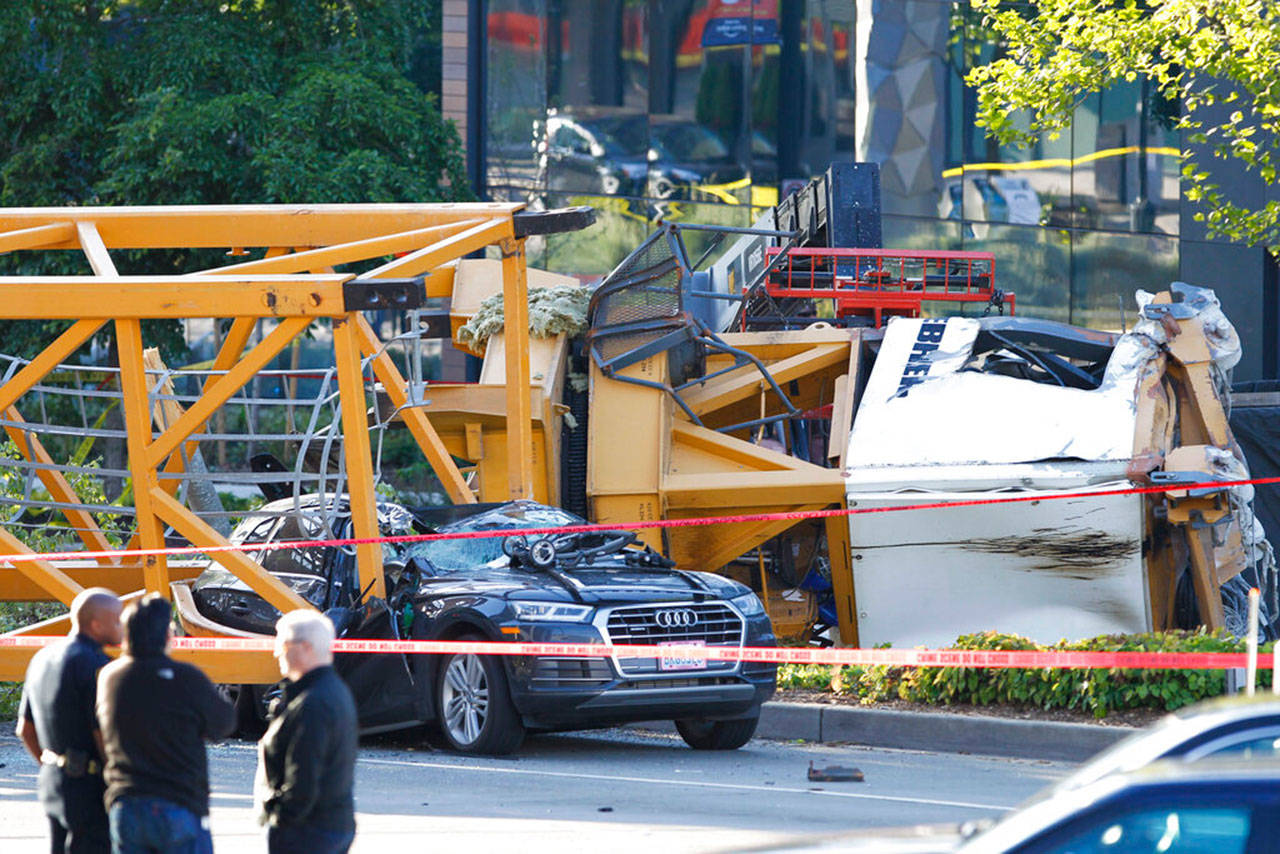 In this April 27, 2019, file photo, emergency crews work at the scene of a construction crane collapse where four people were killed and others were injured in the South Lake Union neighborhood of Seattle. Family members of two of the four people killed in the crane collapse have filed wrongful death suits against companies involved in crane operations at the site. (AP Photo/Joe Nicholson, File)