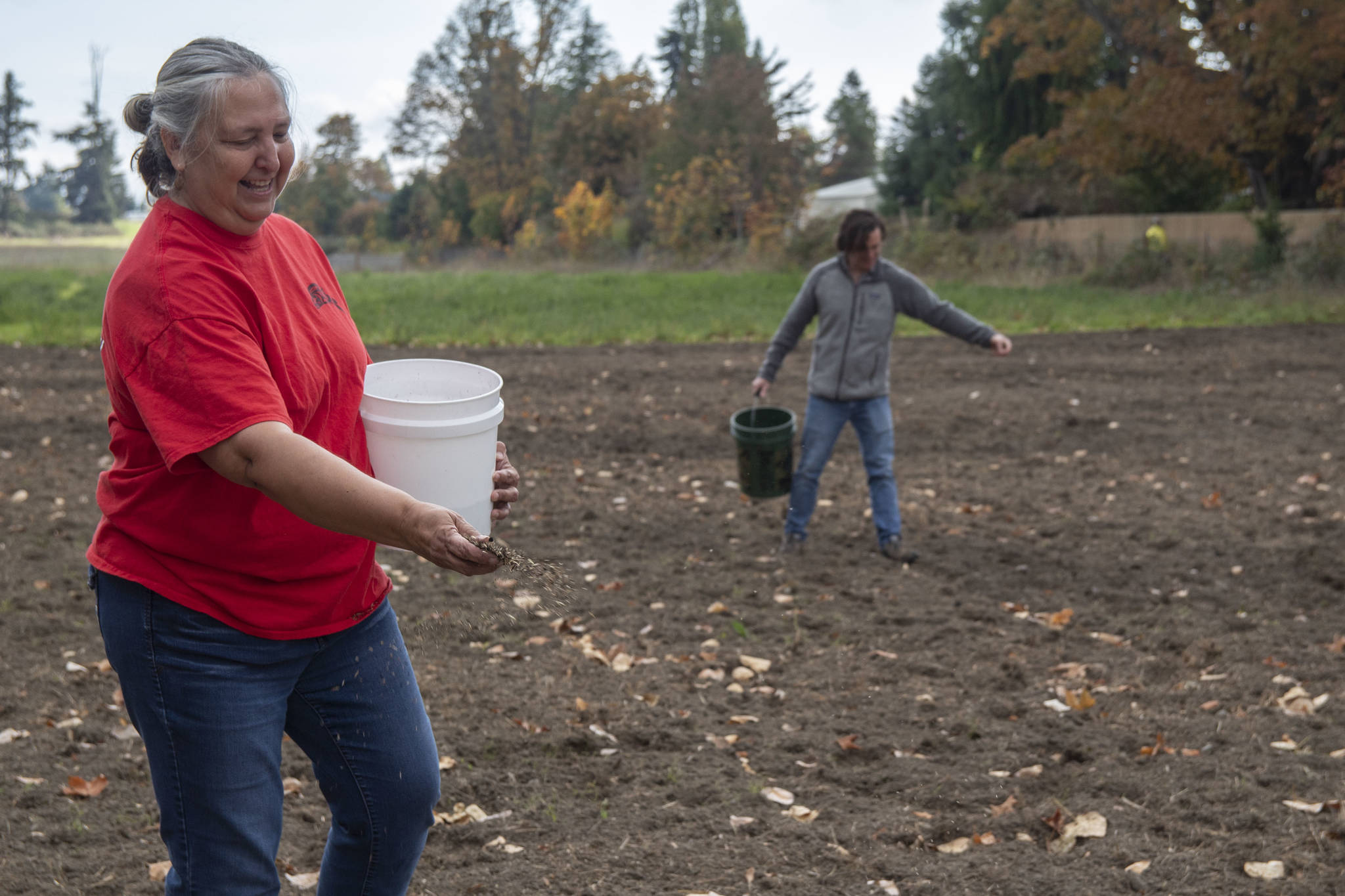 Traditional Foods Project manager Lisa Barrell and volunteer Brock Walker seed the Jamestown S’Klallam Tribe’s new prairie with wildflowers behind the Audubon Dungeness River Center in Sequim. (Tiffany Royal)