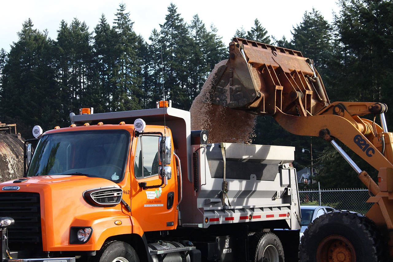 A large loader pours rock salt into the back of a salt truck and plow at the Jefferson County Public Works facility in Port Hadlock on Thursday as crews prepare for the possible snow in the upcoming days. (Zach Jablonski/Peninsula Daily News)