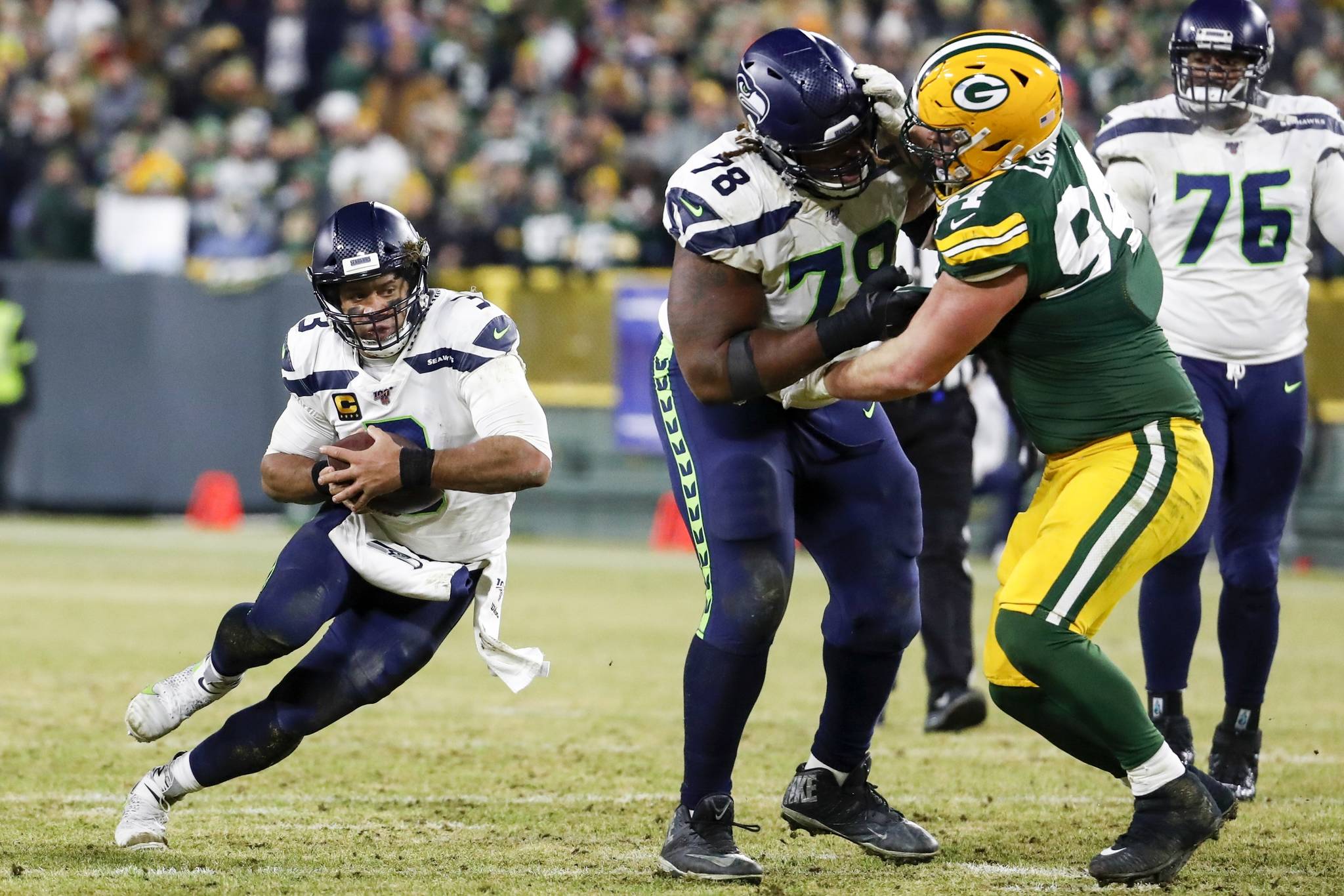 Seattle Seahawks’ Russell Wilson runs for a first down during the second half of an NFL divisional playoff football game against the Green Bay Packers Sunday, Jan. 12, 2020, in Green Bay, Wis. (AP Photo/Matt Ludtke)