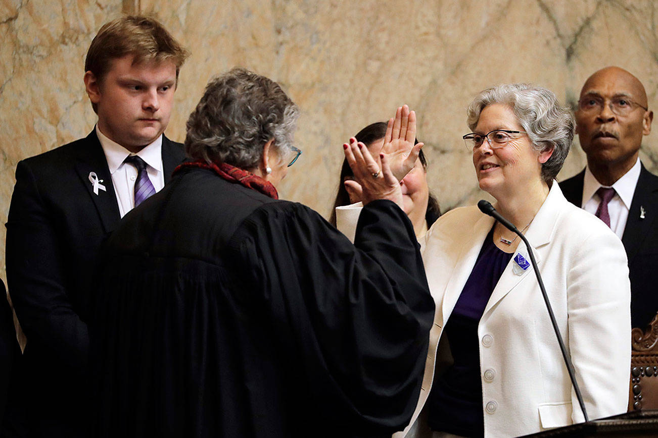 House Speaker Laurie Jinkins, D-Tacoma, second from right, is sworn in by former Washington Supreme Court Chief Justice Mary Fairhurst, second from left, Monday, on the first day of the 2020 session of the Washington legislature at the Capitol in Olympia. (Ted S. Warren/The Associated Press)