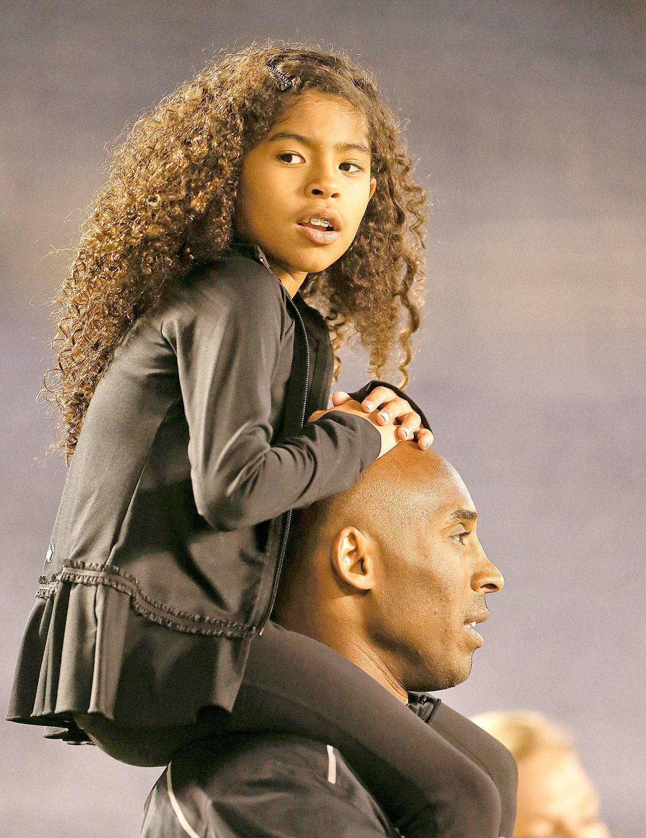 Gianna Maria-Onore Bryant sits on the shoulders of her father, Kobe, as they attend the women’s soccer match between the United States and China Thursday, April 10, 2014, in San Diego. Bryant, the 18-time NBA All-Star who won five championships and became one of the greatest basketball players of his generation during a 20-year career with the Los Angeles Lakers, died in a helicopter crash Sunday, Jan. 26, 2020. Gianna also died in the crash. (AP Photo/Lenny Ignelzi, file)