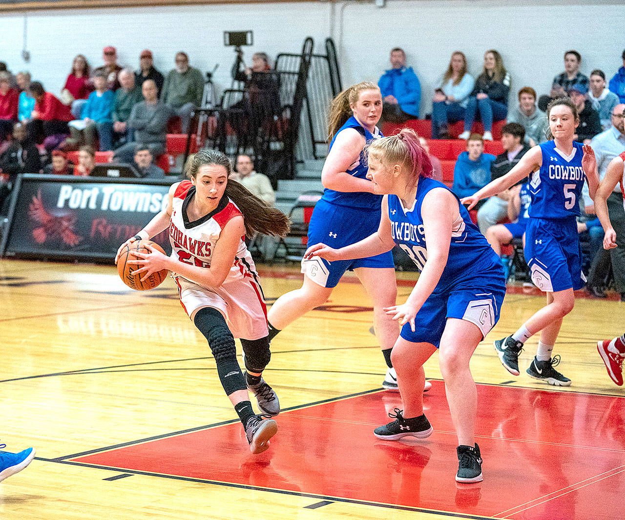 Lady Redhawk Sorina Johnston drives around Chimacum’sKatrina Crawford, (30), during a hotly contested game on Monday in Port Townsend. (Steve Mullensky/for Peninsula Daily News)