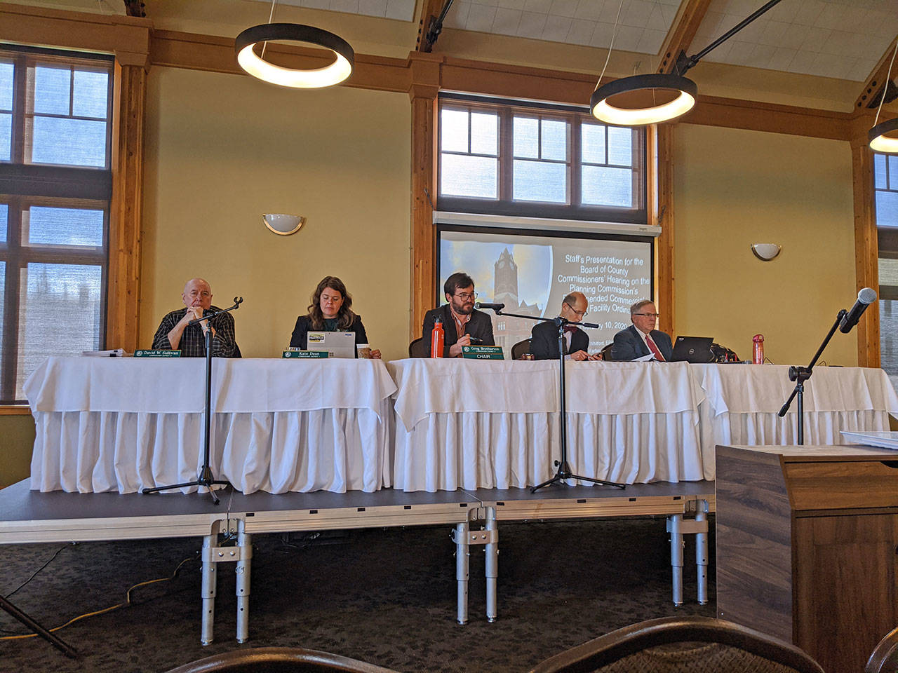 Jefferson County commissioners David Sullivan, left, Kate Dean and Greg Brotherton, along with county administrator Philip Morley and deputy civil prosecuting attorney Philip Hunsucker, conducted a public hearing regarding a possible extension to the current shooting range moratorium at Fort Worden on Monday afternoon. (Zach Jablonski/Peninsula Daily News)