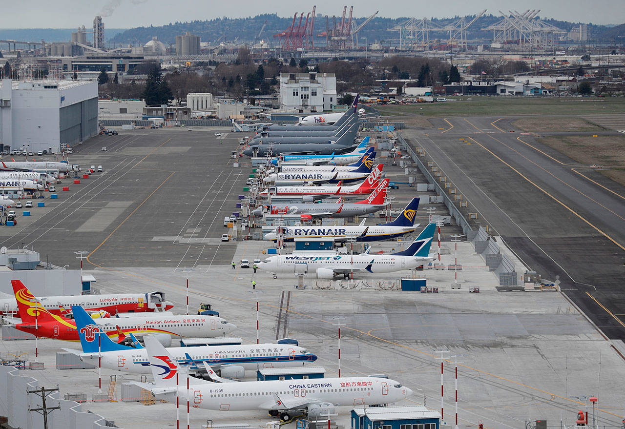 This Feb. 23, 2018, file photo shows cranes from the Port of Seattle in the background and airplanes parked at a Boeing facility at Boeing Field in Seattle. The U.S. Department of Justice filed a federal lawsuit Monday, Feb. 10, 2020, against King County seeking to overturn the county’s ban on all immigration deportation flights at the airport. (Ted S. Warren/The Associated Press file)