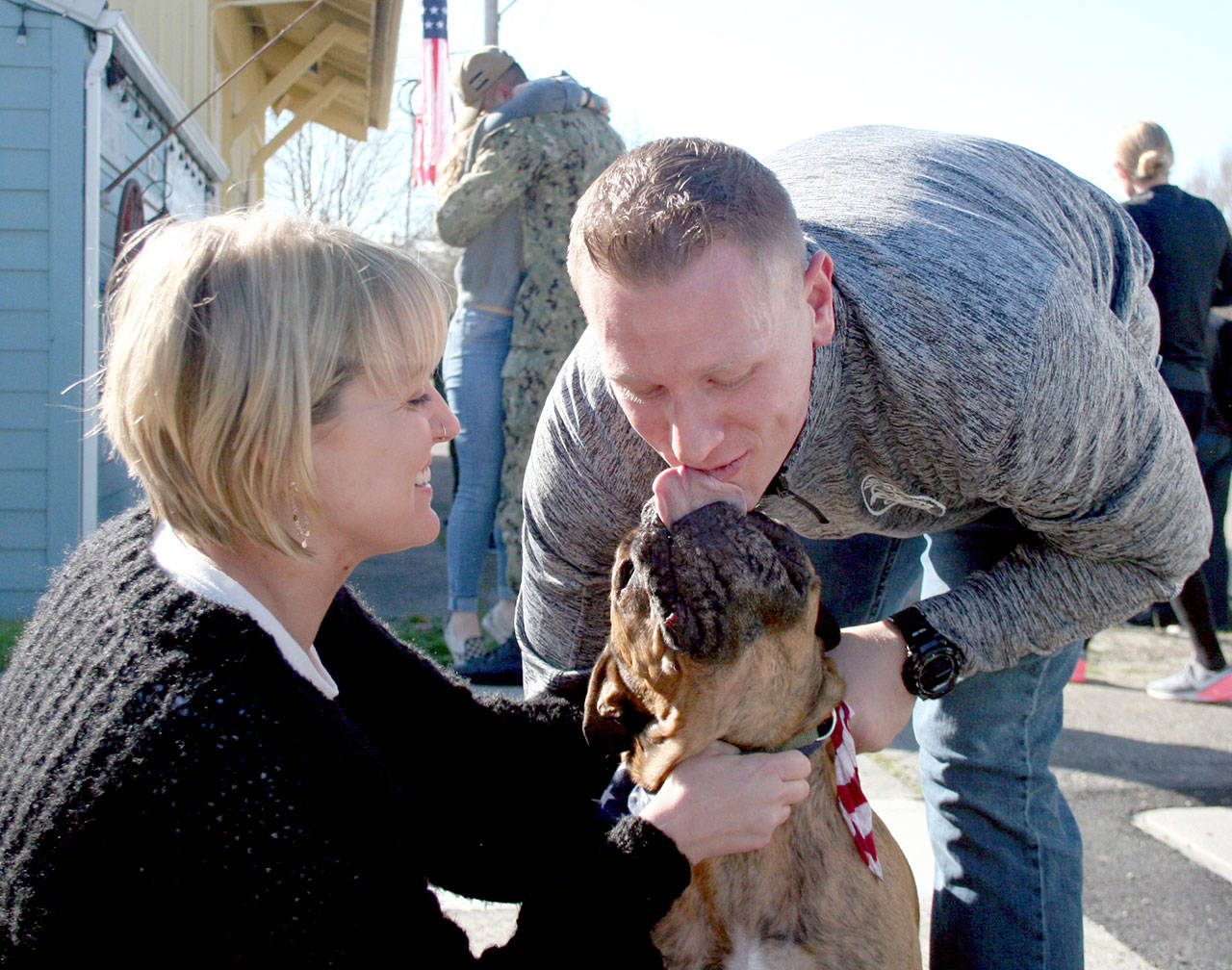 Kate Krusely, left, and Cash greet U.S. Navy Lt. Julian Krusely on Tuesday outside of the Chamber of Jefferson County in Port Townsend. The Kruselys recently moved to Gig Harbor, although Julian departed on the USS Nimitz after he had been in his new house for just five days. (Brian McLean/Peninsula Daily News)