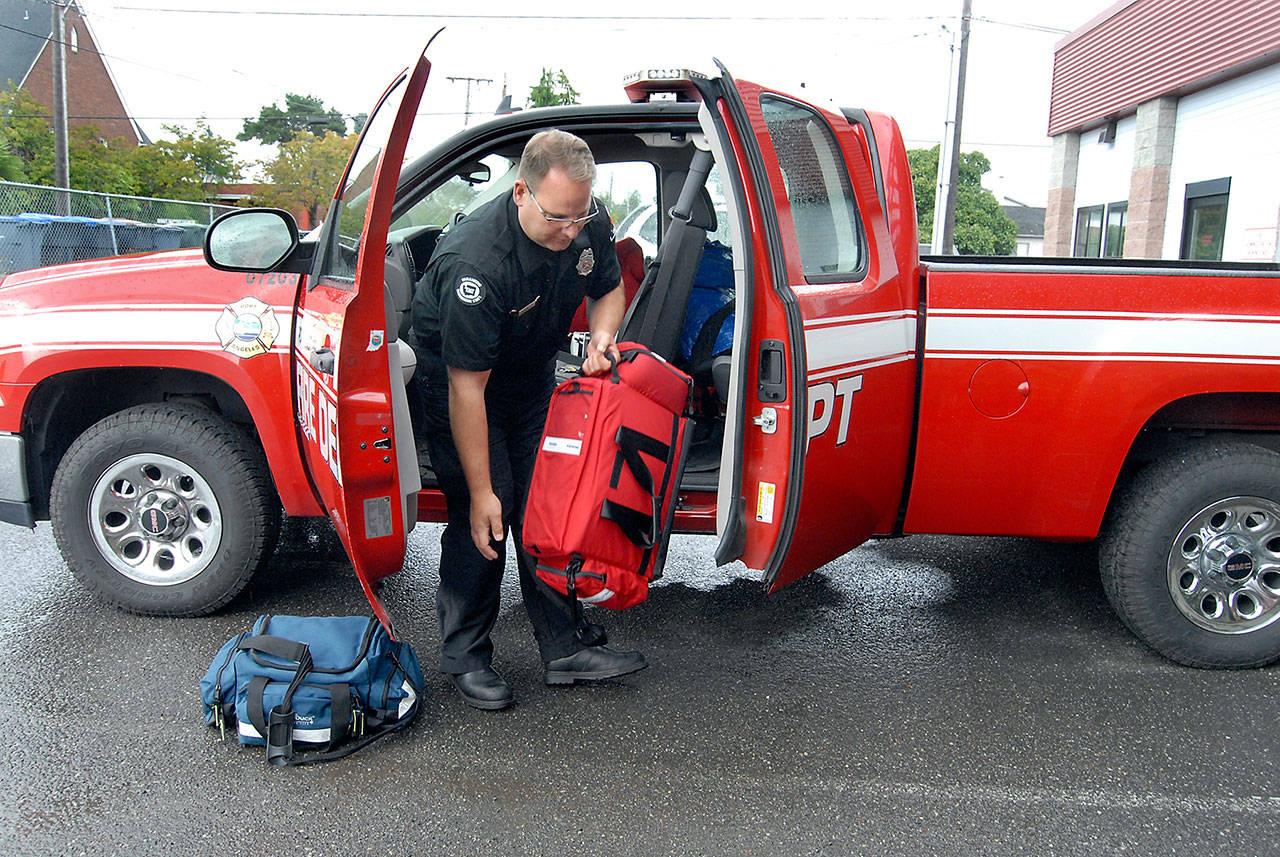 Firefighter/EMT Daniel Montana loads medical equipment in a Port Angeles Fire Department utility vehicle that he uses in place of a full-sized ambulance to cover non-emergency 9-1-1 calls in this file photo from Sept. 13, 2019. (Keith Thorpe/Peninsula Daily News file)