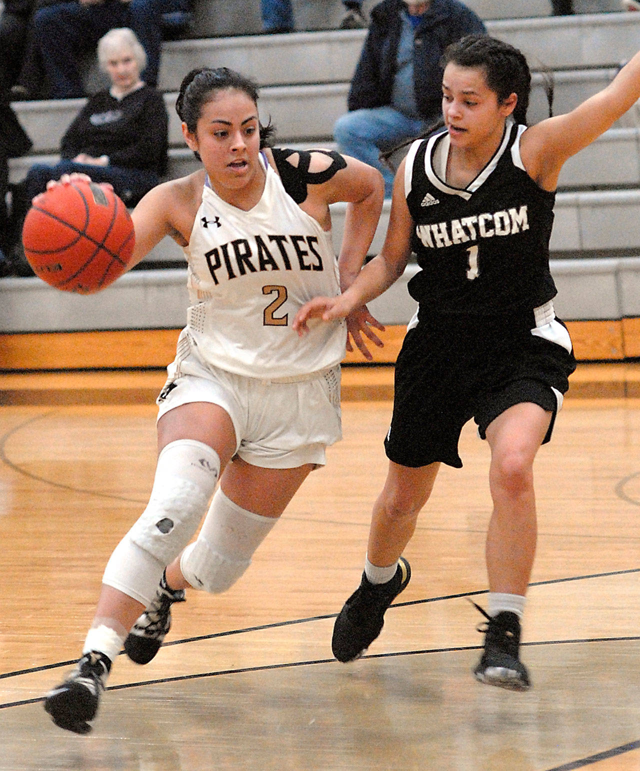 Peninsula’s Lellani Padilla, left, pushes past Whatcom’s Carmelita Rodriguez during Wednesday’s game in Port Angeles. (Keith Thorpe/Peninsula Daily News)
