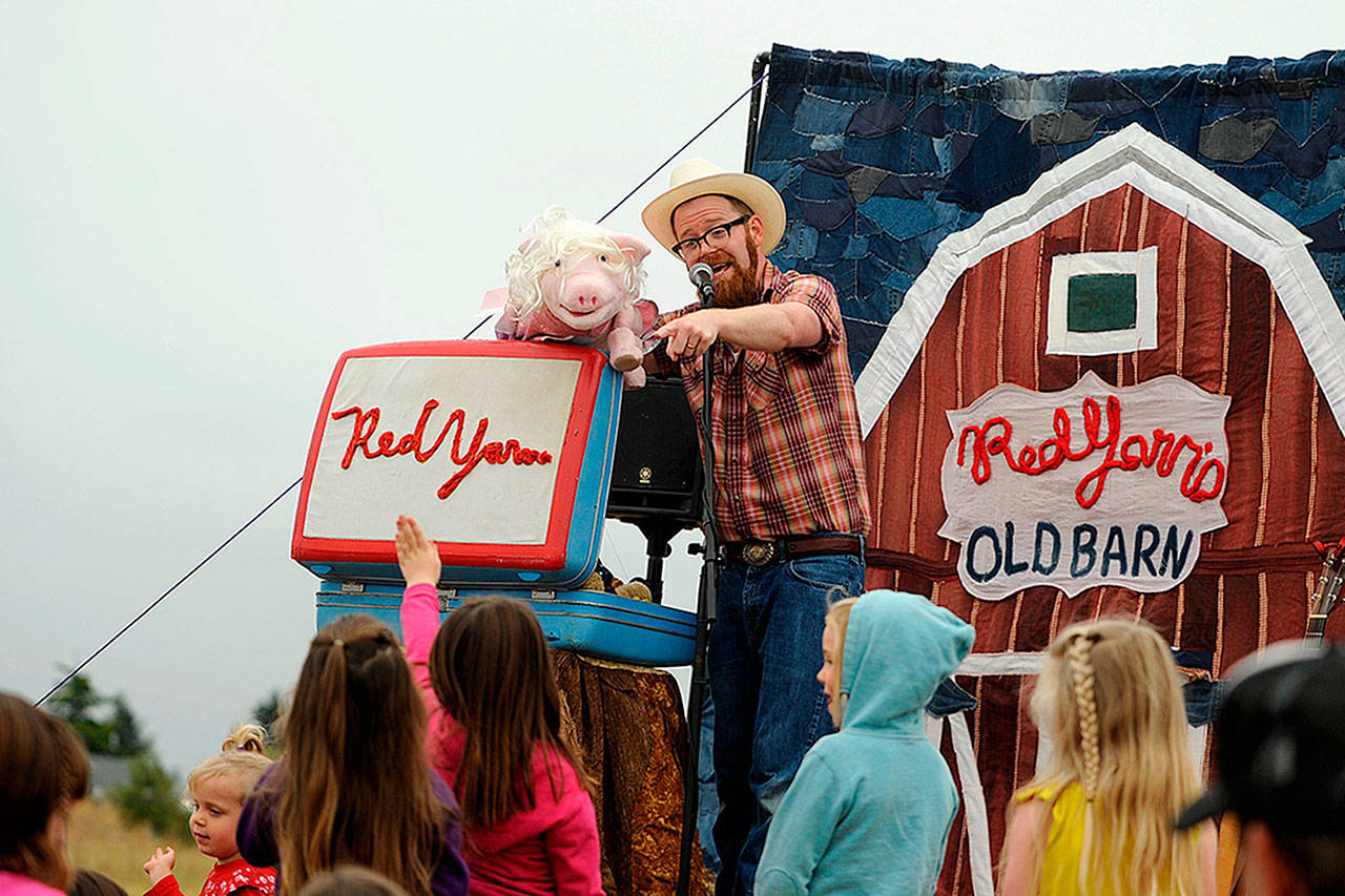 Andy Furgeson, aka Red Yarn, chats with Percy the pig during his live show at the Sequim Library in July 2019. Red Yarn brings some family-friendly entertainment to the Feb. 29 Beat the Blues Barn Dance. (Matthew Nash/Olympic Peninsula News Group)