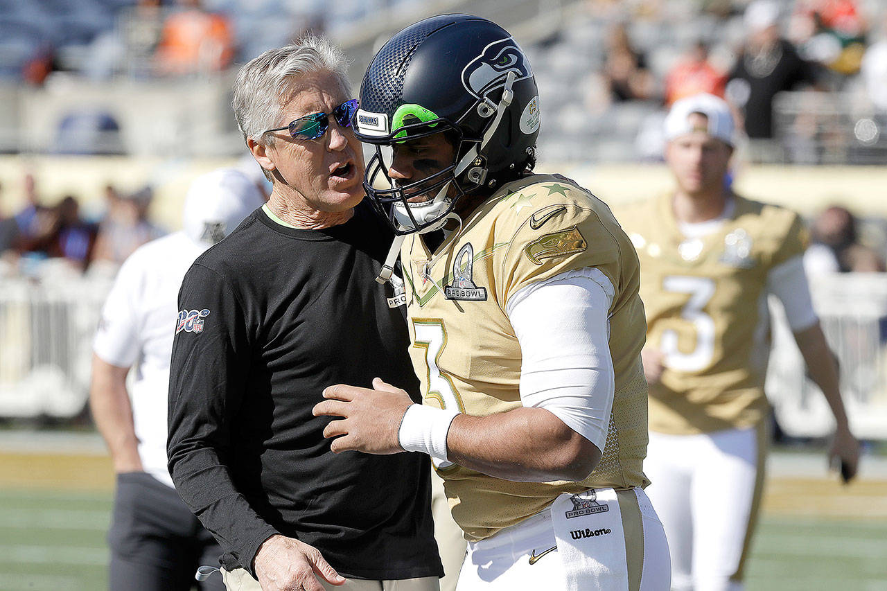 NFC head coach Pete Carroll of the Seattle Seahawks, left, talks to quarterback Russell Wilson of the Seattle Seahawks (3) before the NFL Pro Bowl football game Sunday, Jan. 26, 2020, in Orlando, Fla. (Chris O’Meara/The Associated Press)