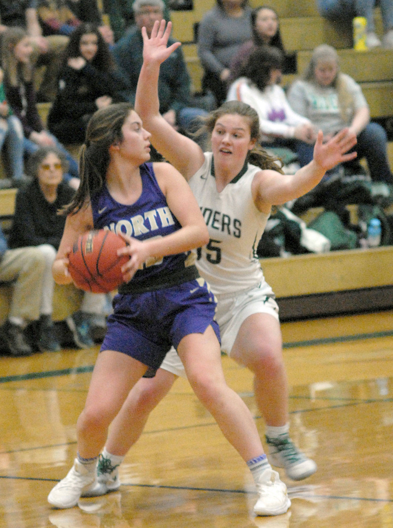 North Kitsap’s Elizabeth Kimmel, left, looks to pass while defended by Port Angeles’ Myra Walker in Port Angeles in January. The Port Angeles girls begin play in the state 2A basketball tournament today. (Keith Thorpe/Peninsula Daily News)