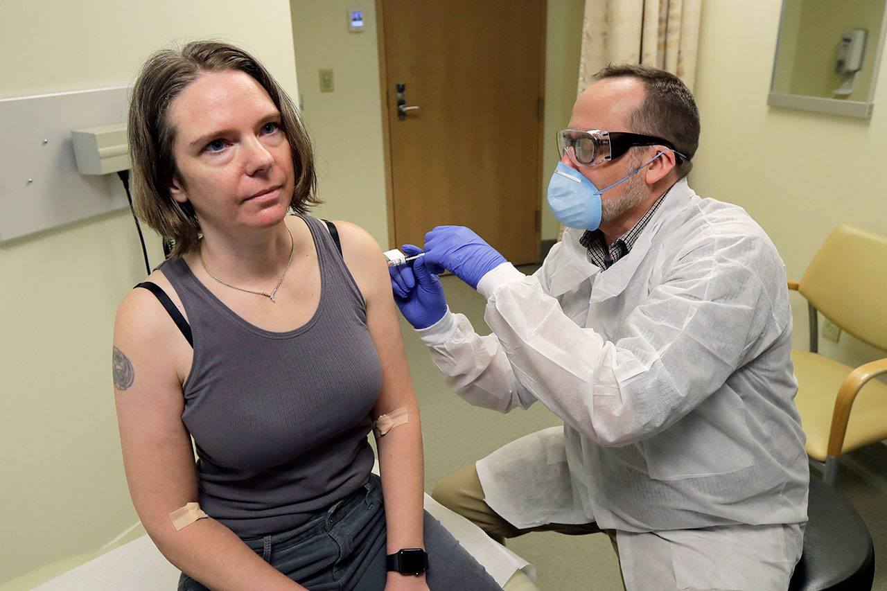 A pharmacist gives Jennifer Haller, left, the first shot in the first-stage safety study clinical trial of a potential vaccine for COVID-19, the disease caused by the new coronavirus Monday, March 16, 2020, at the Kaiser Permanente Washington Health Research Institute in Seattle. (Ted S. Warren/The Associated Press)