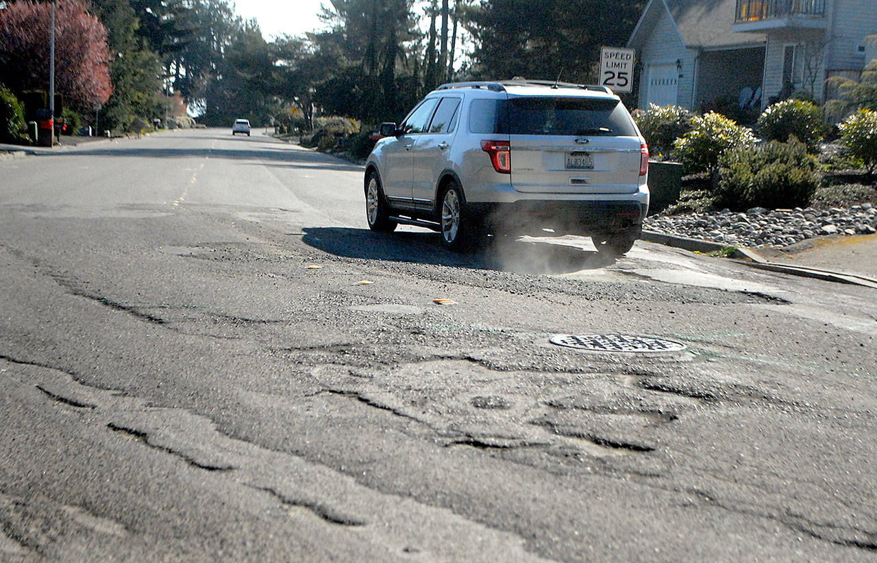 A vehicle navigates over rough patches of damaged pavement at north end of South N Street on the west side of Port Angeles on Thursday, April 9, 2020. (Keith Thorpe/Peninsula Daily News)