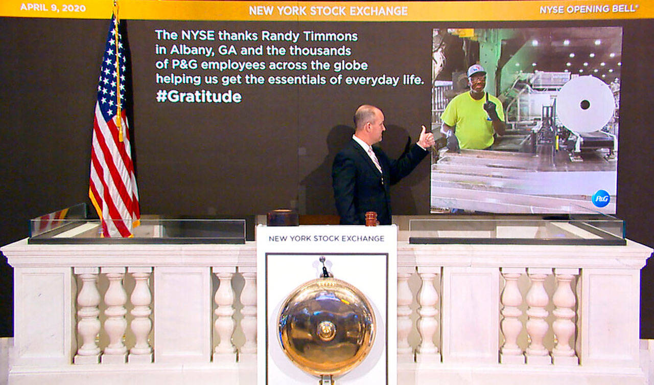 In this photo taken from video provided by the New York Stock Exchange, Chief Security Officer Kevin Fitzgibbons rings the opening bell at the NYSE, while recognizing Randy Timmons in Albany, Ga., and thousands of employees of the Proctor & Gamble Company on Thursday, April 9, 2020. (New York Stock Exchange via AP)