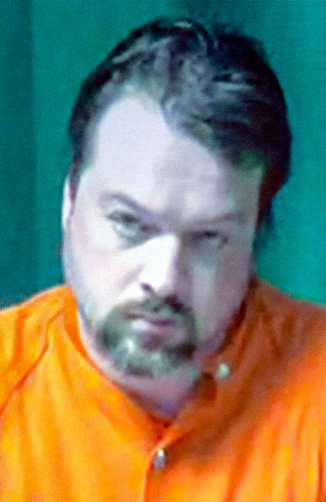 Matthew Wetherington, left, appears on video in Clallam County Superior Court Monday. Wetherington, accused of killing his wife and three children, was ordered held in the Clallam County jail on $5 million bail.