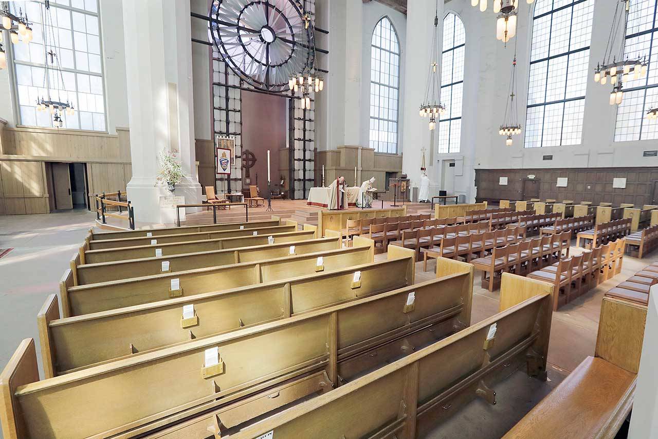 The Very Rev. Steven L. Thomason, left, and the Right Rev. Gregory H. Rickel, bow to an empty sanctuary as they begin a live streamed Easter service at Saint Mark’s Episcopal Cathedral Sunday on in Seattle. Christians around the world are celebrating Easter at a distance, with many churches closed and family gatherings canceled amid wide-ranging shutdowns due to the coronavirus pandemic. (Elaine Thompson/The Associated Press)