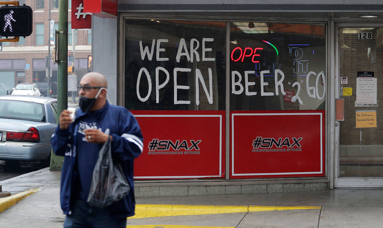 A man wears a face mask as he leaves a business that remains open in downtown San Antonio on Wednesday, April 22, 2020. San Antonio remains under stay-at-home orders due to the COVID-19 outbreak and residents are required to wear face coverings or masks whenever in public. (Eric Gay/Associated Press)