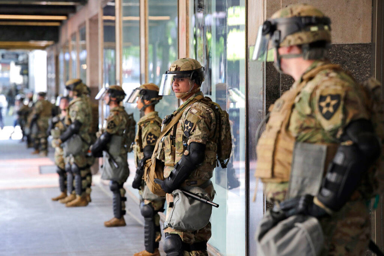 Unarmed Washington National Guard soldiers stand guard outside a previously closed Macy’s department store as a protest begins nearby Monday, June 1, 2020, in Seattle, following protests over the weekend over the May 25 death of George Floyd, a black man who was in police custody in Minneapolis. Washington Gov. Jay Inslee ordered a statewide activation of unarmed Washington National Guard troops a day earlier, adding to his earlier authorization of at least 600 troops to help in Seattle and Bellevue. (Elaine Thompson/Associated Press)