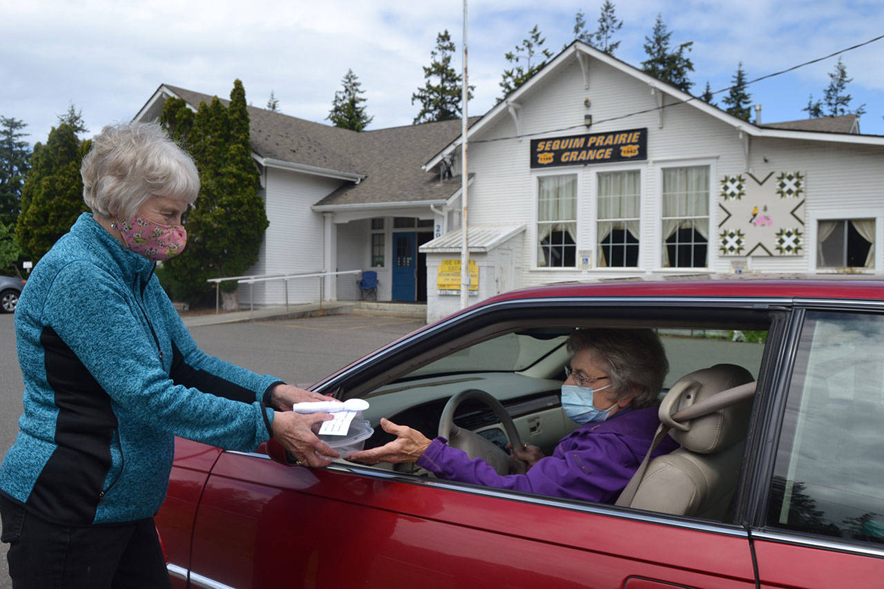 Loretta Bilow holds a practice run with Bonnie Hagberg for the Sequim Prairie Grange’s upcoming Drive-Up Ice Cream Social. (Matthew Nash/Olympic Peninsula News Group)