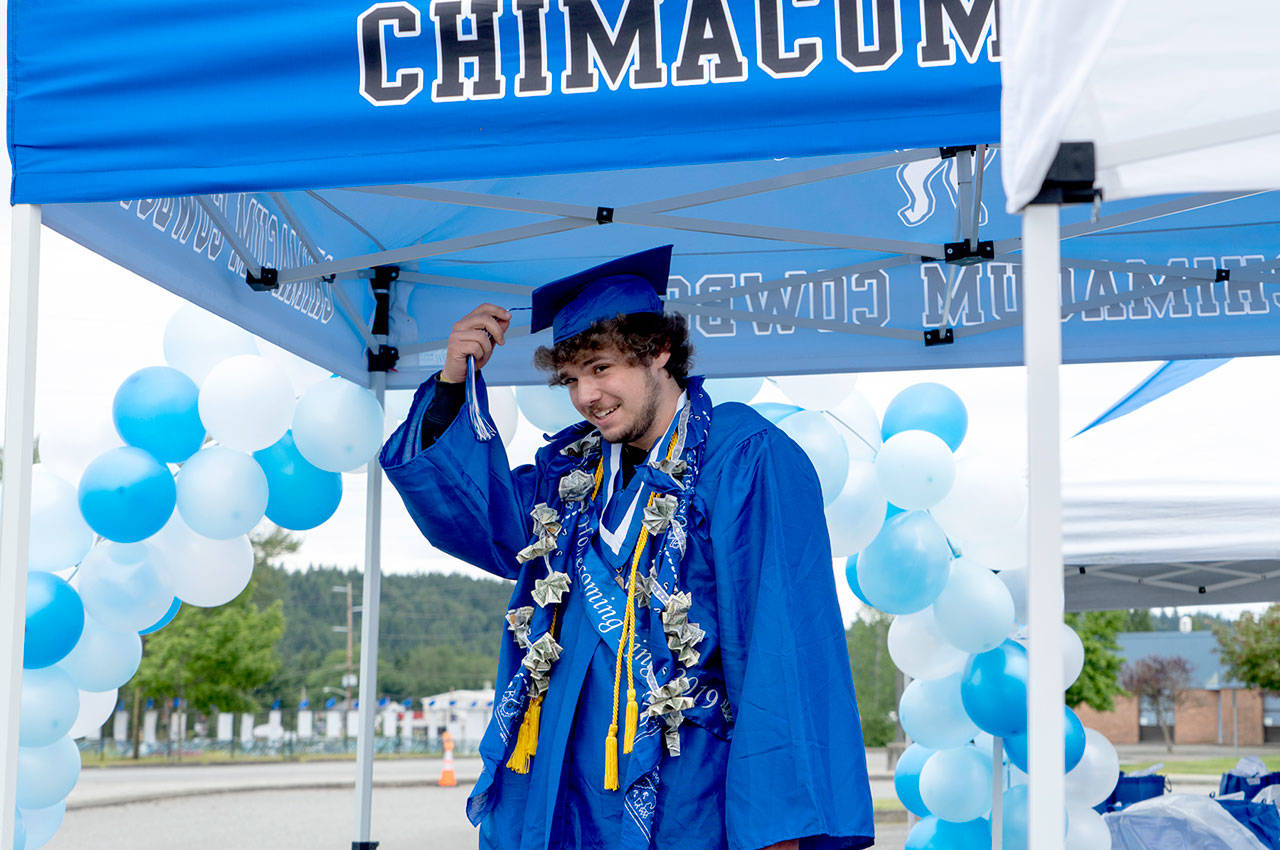 Stephen Calkins, 2020 graduate of Chimacum High School, switches hes tassle to signify that he graduated during a drive-by graduation exercise at Chimacum High School on Saturday. (Steve Mullensky/for Peninsula Daily News)