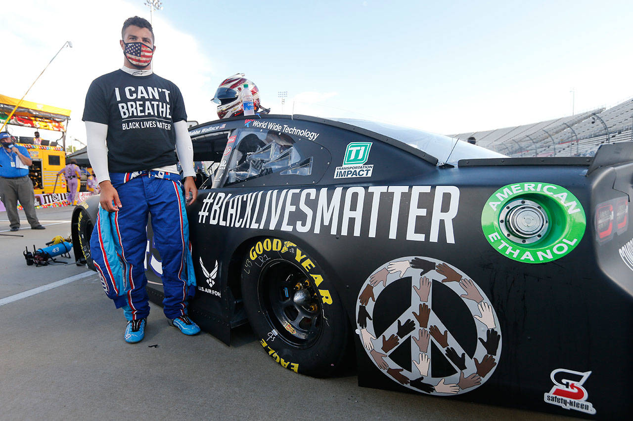In this June 10, 2020, file photo, driver Bubba Wallace waits for the start of a NASCAR Cup Series auto race in Martinsville, Va. Bubba Wallace now counts Spike Lee and Demi Lovato – his admitted celebrity crush – as those loudly in his corner since he’s become the leader of NASCAR’s push for change. (Steve Helber/Associated Press file)
