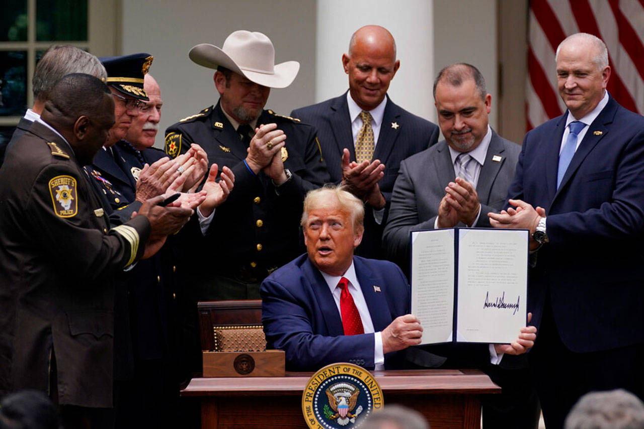 Law enforcement officials applaud after President Donald Trump signed an executive order on police reform, in the Rose Garden of the White House on Tuesday, June 16, 2020, in Washington. (Evan Vucci/Associated Press)