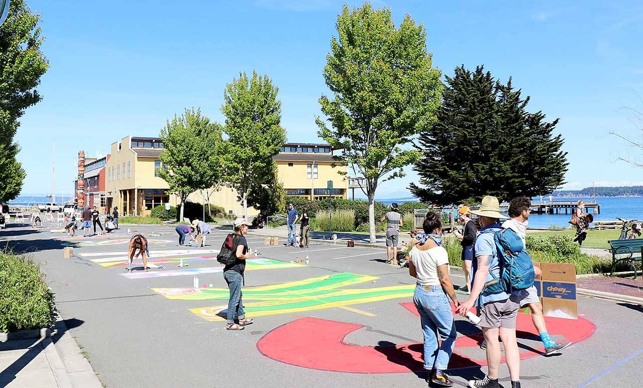 Ahead of today’s Juneteenth celebration and march, members of the Jefferson County Chapter of Black Lives Matter and the City of Port Townsend Arts Commission paint a temporary art installation along the north end of Water Street on Thursday. The words Black Lives Matter are outlined and colored on the street. Juneteenth begins at 11 a.m. today at Pope Marine Park with speakers and music. A march is planned starting at 11:45 a.m. or noon to go the intersection of Haines Place and Sims Way. (Ken Park/Peninsula Daily News)