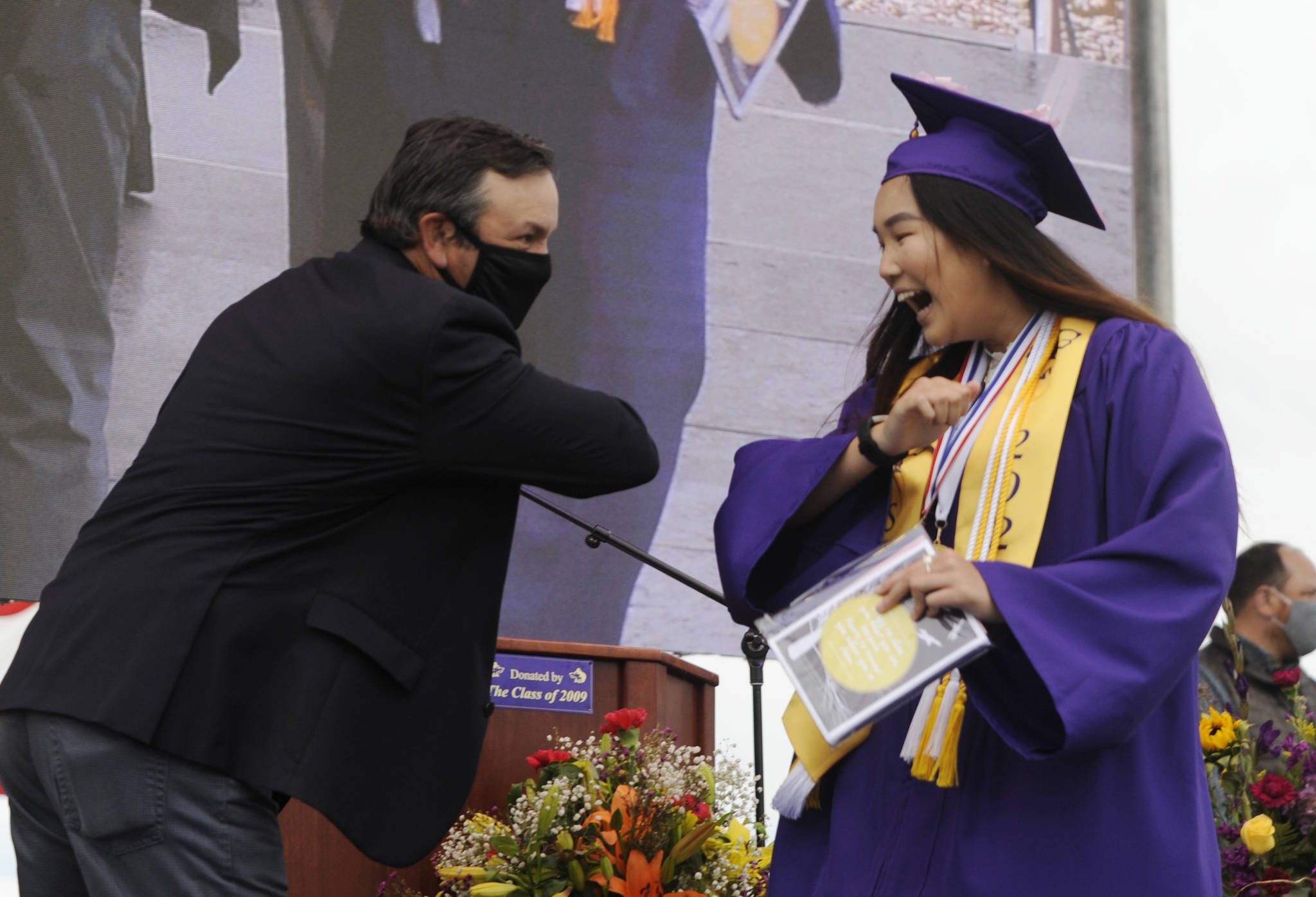 Michael Dashiell /Olympic Peninsula News Group After receiving her diploma, class president Erin Dwyer gets an elbow bump from Sequim High School principal Shawn Langston at Friday’s SHS commencement ceremony. Sequim Gazette photo by Michael Dashiell