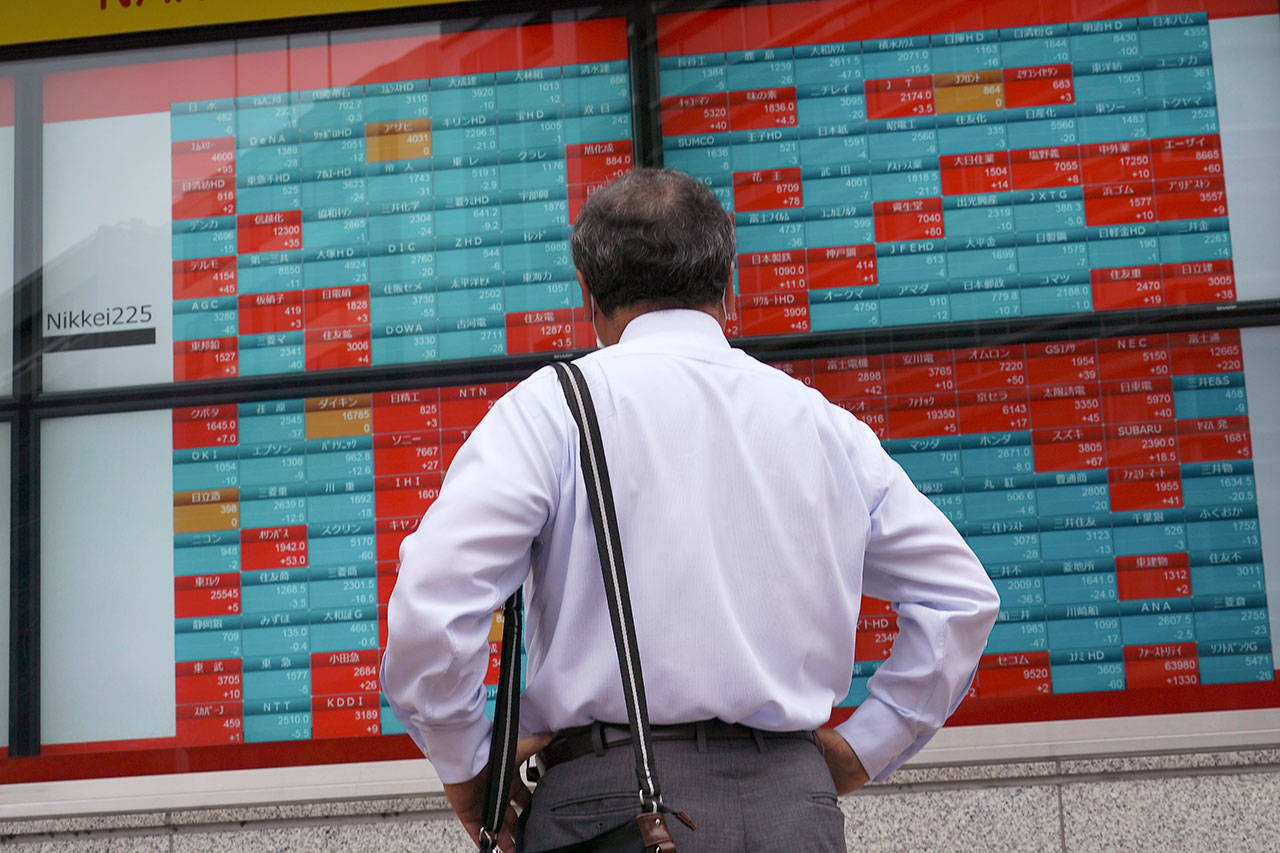 A man looks at an electronic stock board showing Japan’s Nikkei 225 index at a securities firm in Tokyo on Wednesday, June 24, 2020. Asian shares were mostly higher on Wednesday with another mood boost from Wall Street, but fears persist over the surge in coronavirus cases in parts of the world. (AP Photo/Eugene Hoshiko)