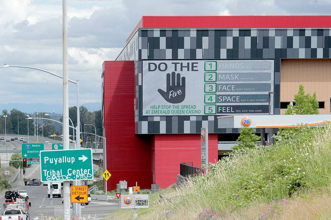 A large video display offers guidelines for reducing the risk of the spread of the coronavirus Thursday at the new Emerald Queen Casino, which is open, and owned by the Puyallup Tribe of Indians in Tacoma. The U.S. economy is stumbling as the viral outbreak intensifies, threatening to slow hiring and deepening the uncertainty for employees, consumers and companies across the country. (Ted S. Warren/The Associated Press)