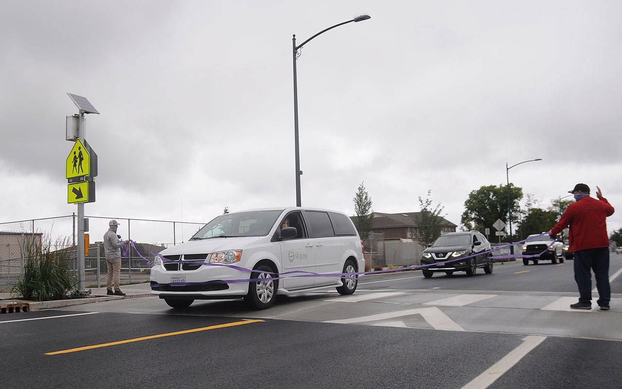 Sequim Mayor Will Armacost cuts the ceremonial ribbon and leads a procession of City of Sequim Vehicles to fete completion the West Fir Street Rehabilitation Project on July 9, 2020. (Michael Dashiell/Olympic Peninsula News Group)