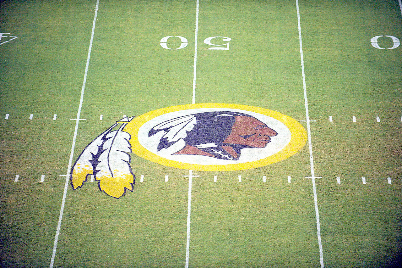 In this Aug. 28, 2009, file photo, the Washington Redskins logo is shown on the field before the start of a preseason NFL football game against the New England Patriots in Landover, Md. The Washington NFL franchise announced Monday that it will drop the “Redskins” name and Indian head logo immediately, bowing to decades of criticism that they are offensive to Native Americans. (Nick Wass/Associated Press file)